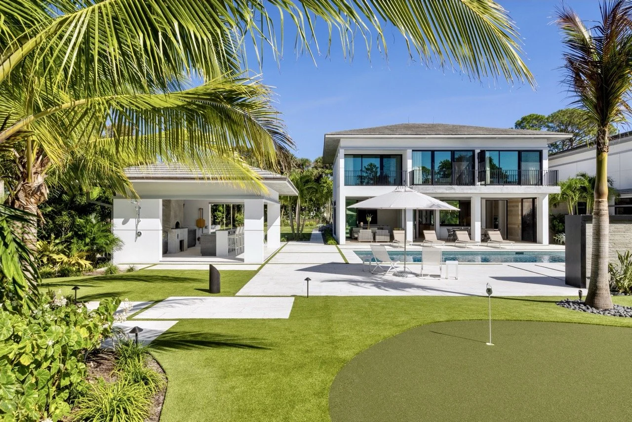 Pool deck, putting green, and pool house at a golf course home in West Palm Beach