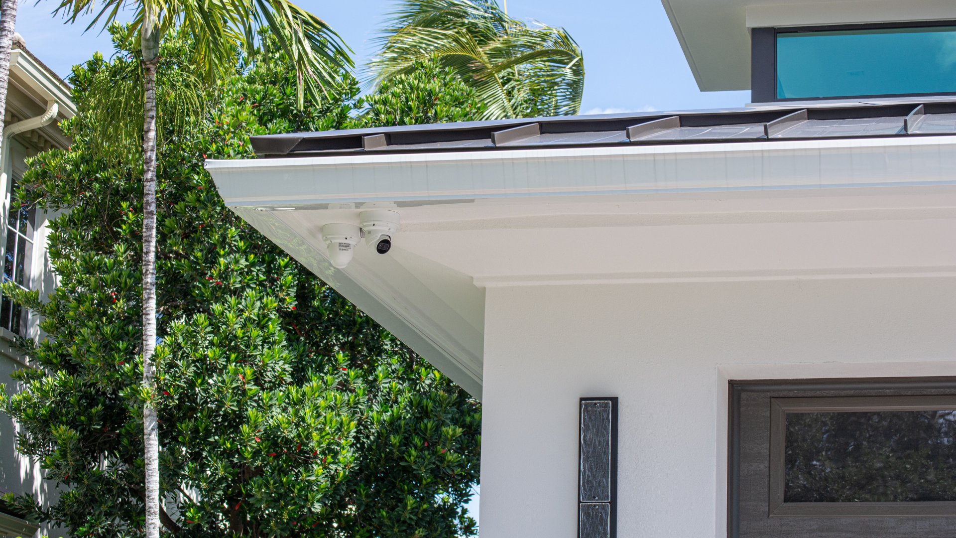 Security cameras mounted under the soffit, placed for approach and entry
