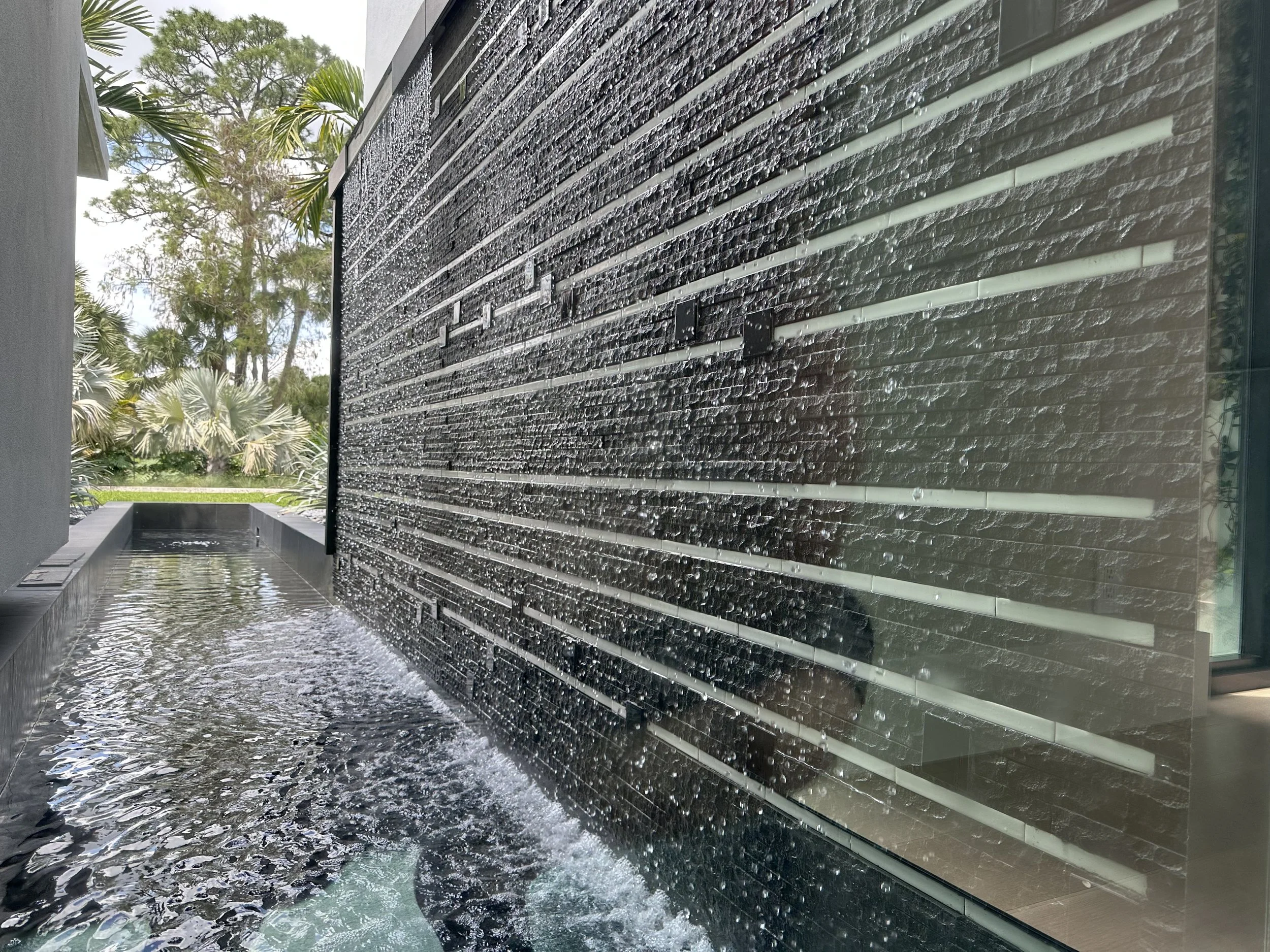 Detail of the lit stone water wall at the courtyard feature