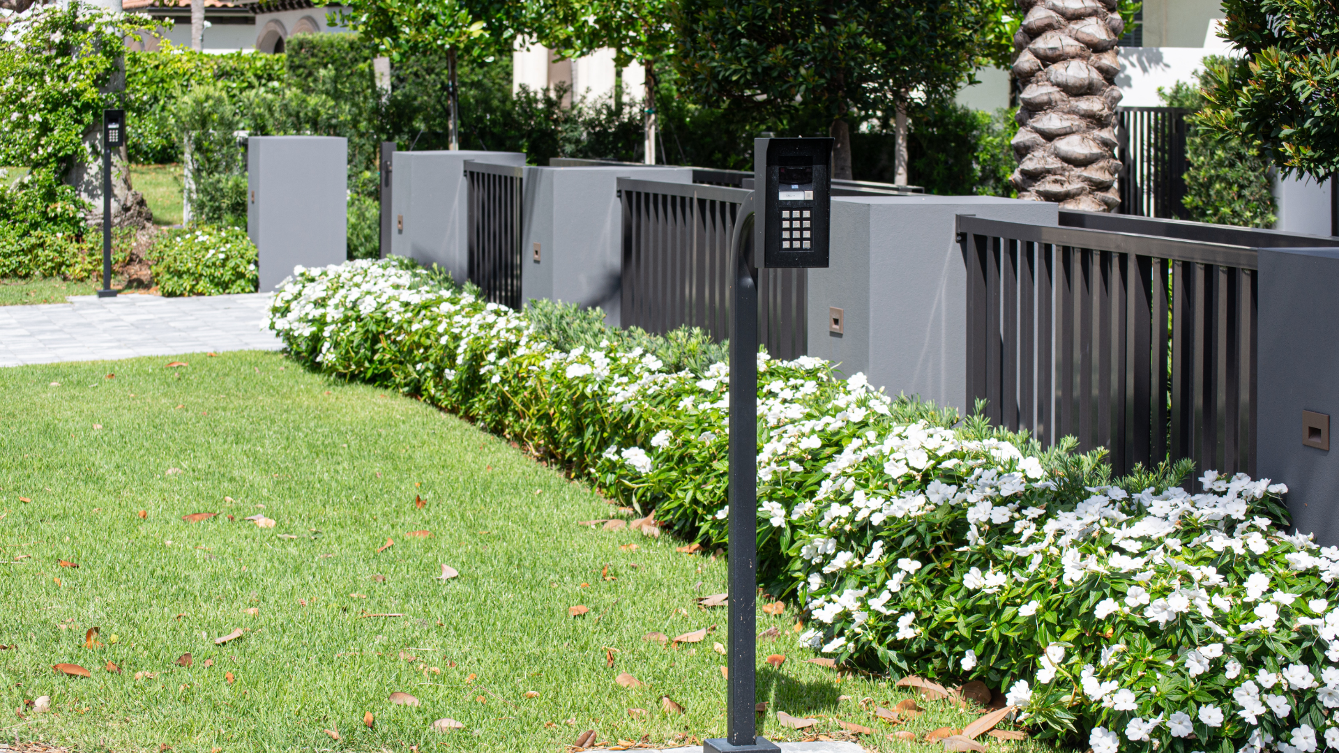 Driveway gate with video callbox and access control set into the landscape design