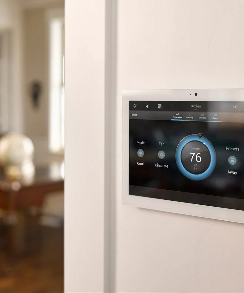 Smart home thermostat mounted on a white wall, displaying the temperature set to 76 degrees Fahrenheit with a circular interface.