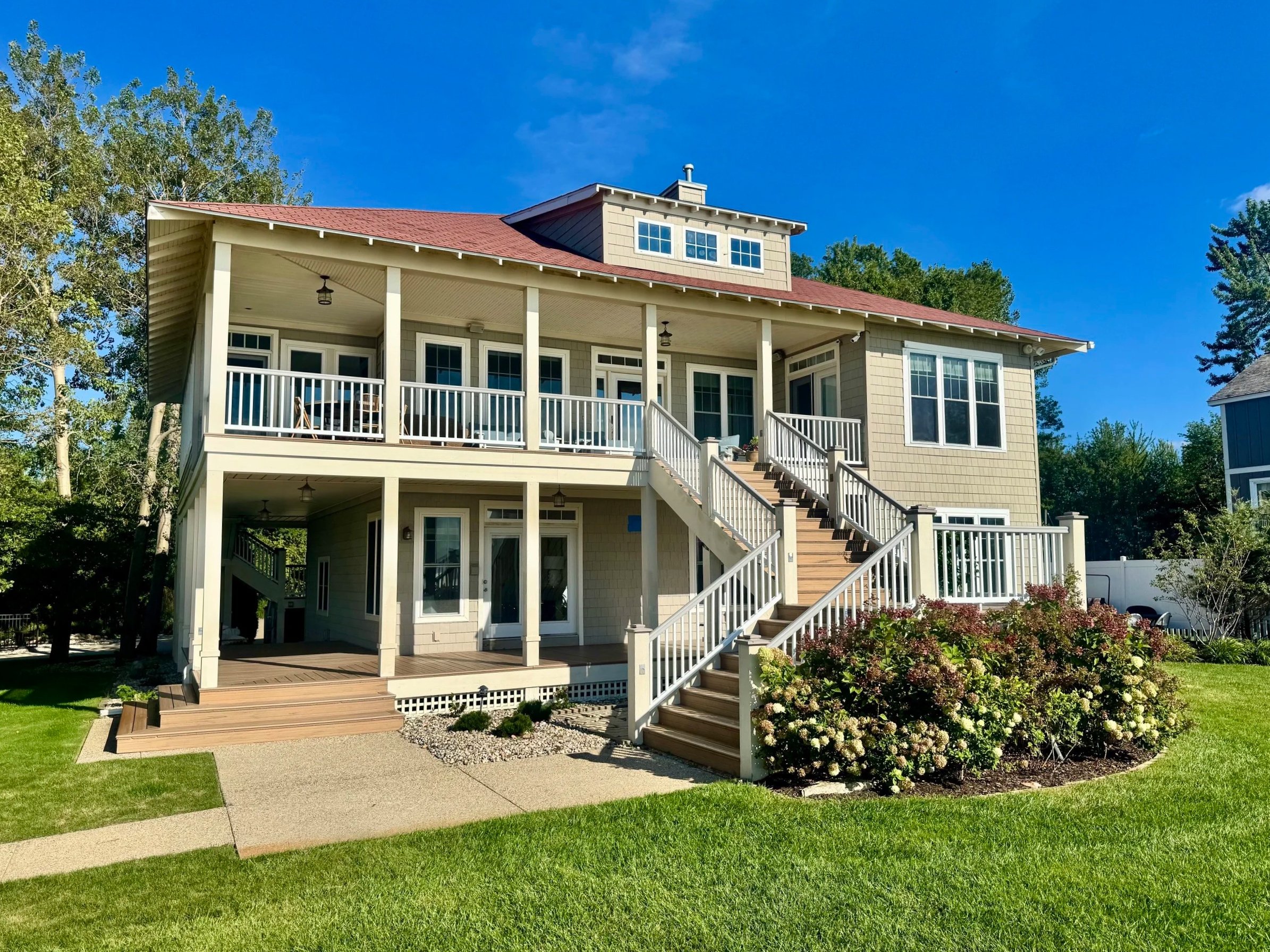 Haven House is a large three-story house with a wrap-around porch and staircase on the waters of Lake Michigan. 