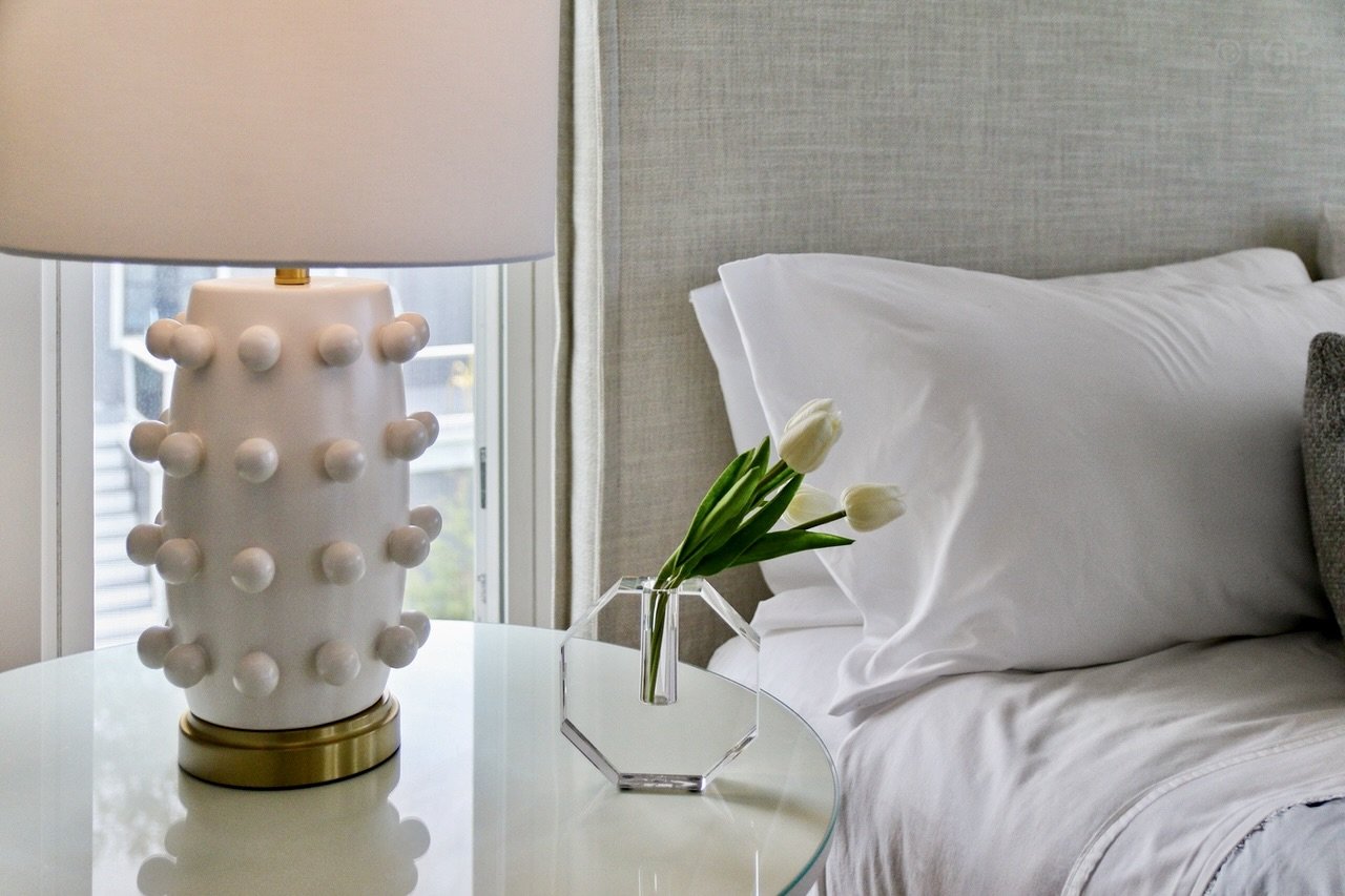 A bedside table in primary suite with King bed.