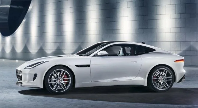 White luxury sports car parked indoors with a modern industrial background.