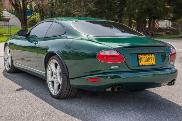 Green sports car parked on a street with a yellow New York license plate.