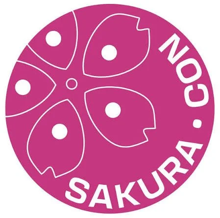 Pink circular logo with four stylized flower petals and the text "SAKURA.COM" around the edge.