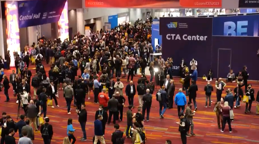 Crowd of people walking in a convention center during CES 2023 event, with signs indicating CTA Center and banners for CES.
