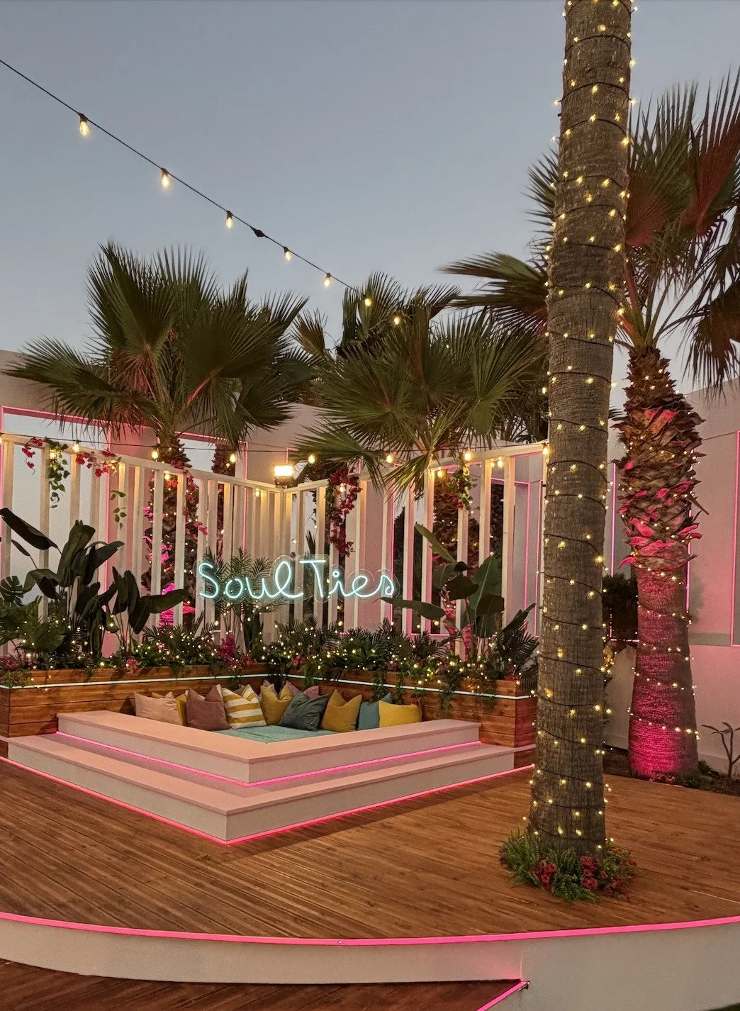 Soul Ties neon lounge with palm trees at dusk