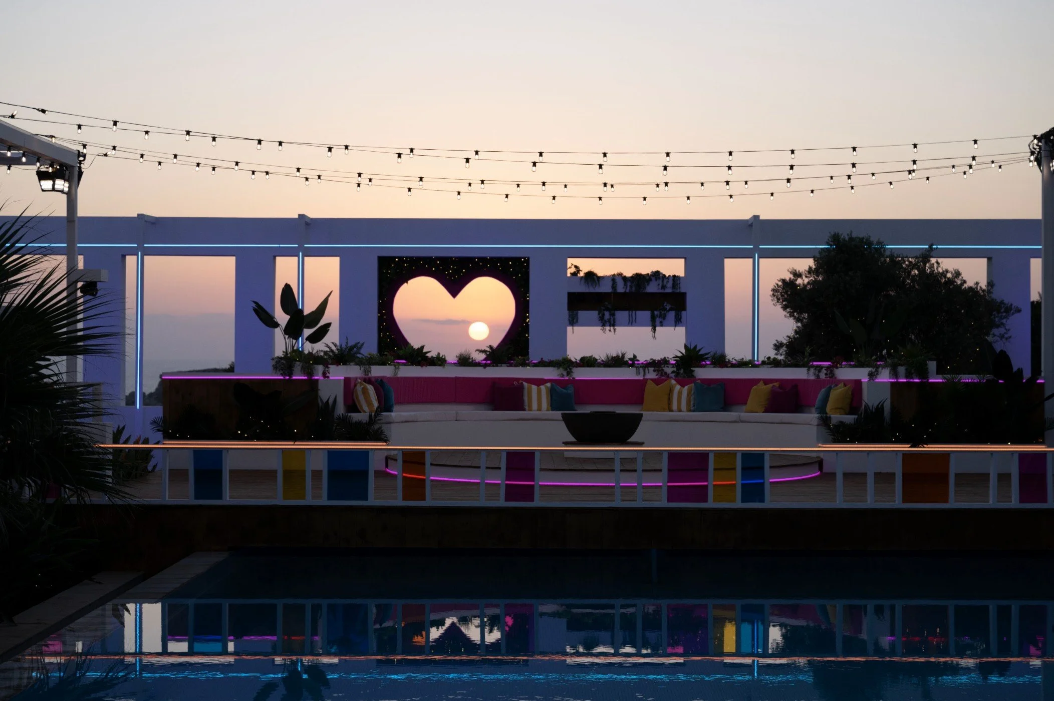 Villa set at sunset with heart-shaped window and string lights
