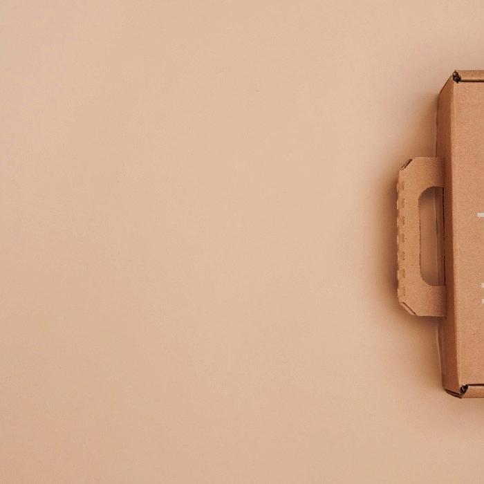 Part of a cardboard box with a handle on a beige background
