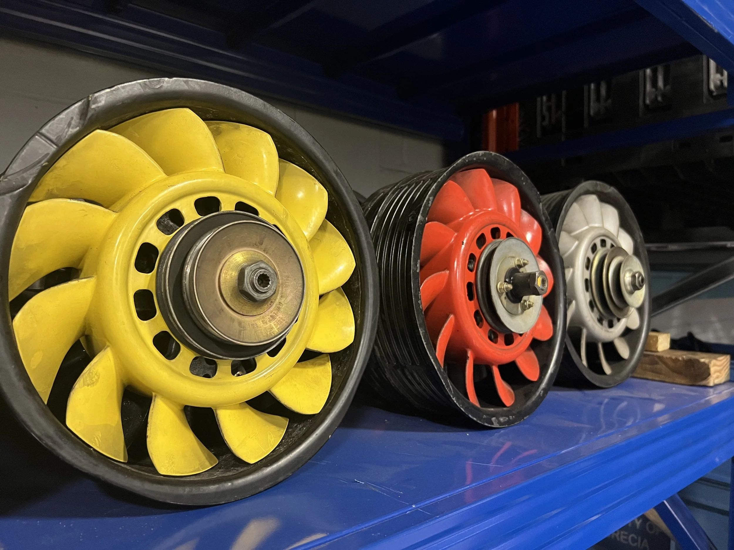 Colorful fans displayed vertically on a storage shelf.