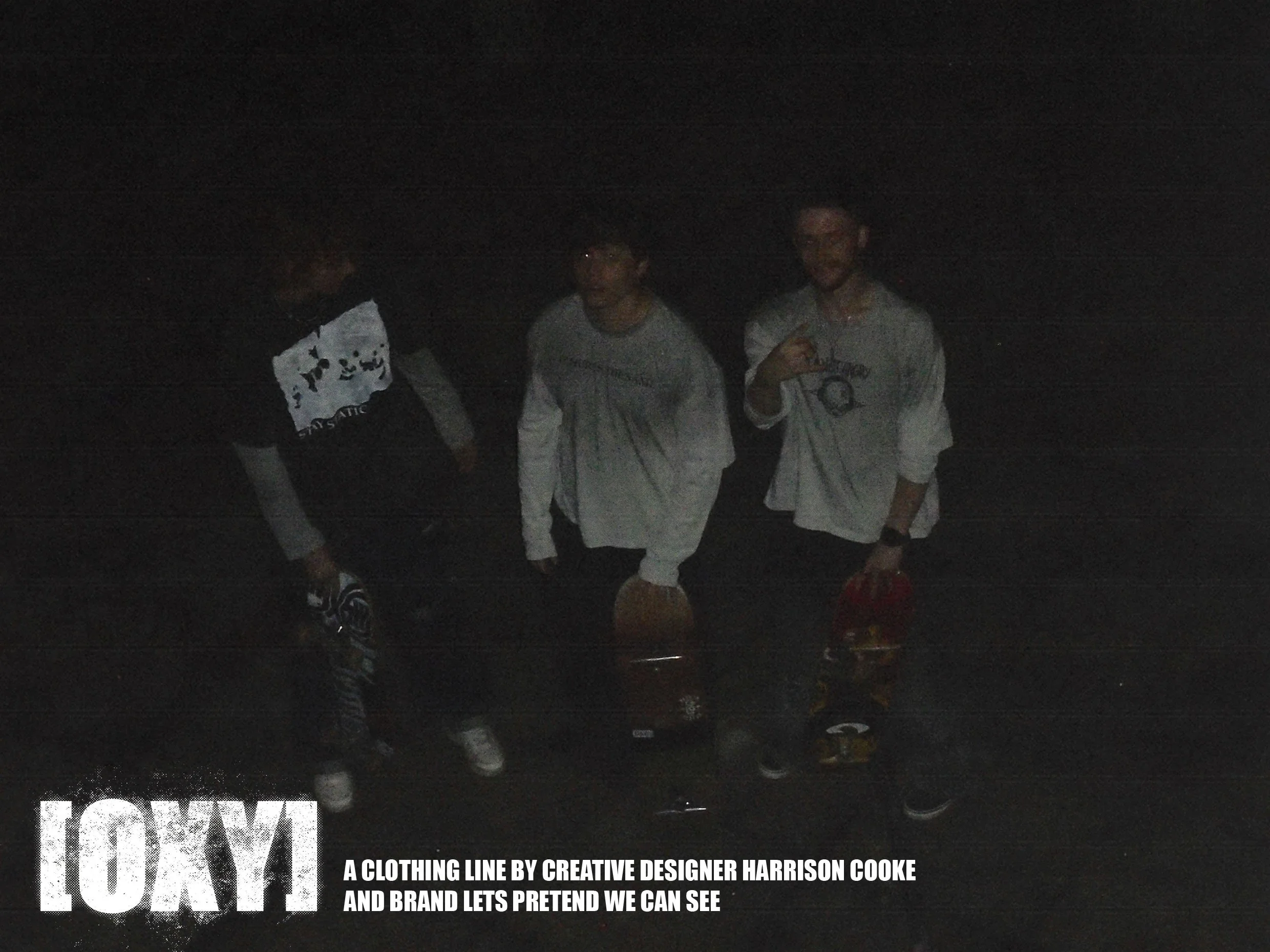 Four young men standing together outdoors at night, posing for a photo. They are dressed in casual clothing and are standing close to each other.