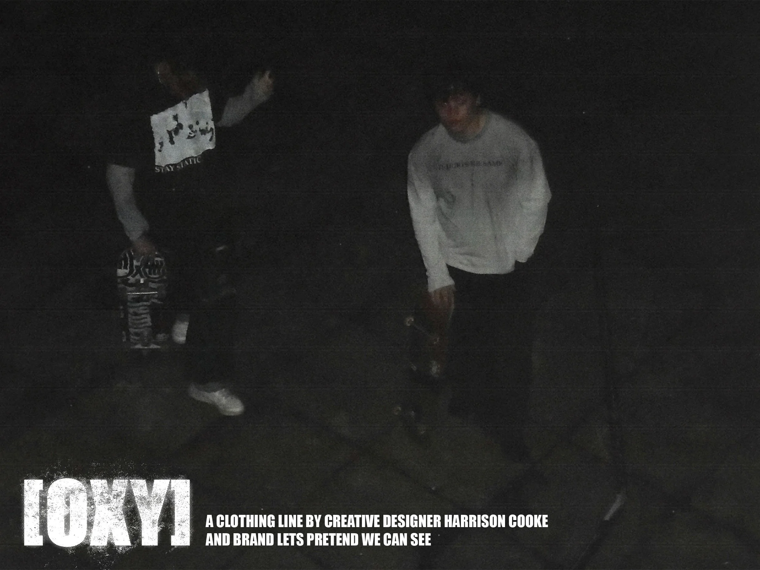 Two individuals wearing casual clothing, one with a patterned shirt and striped pants, appear to be on a dark street or outdoor setting at night. The image is dark and not clearly visible.