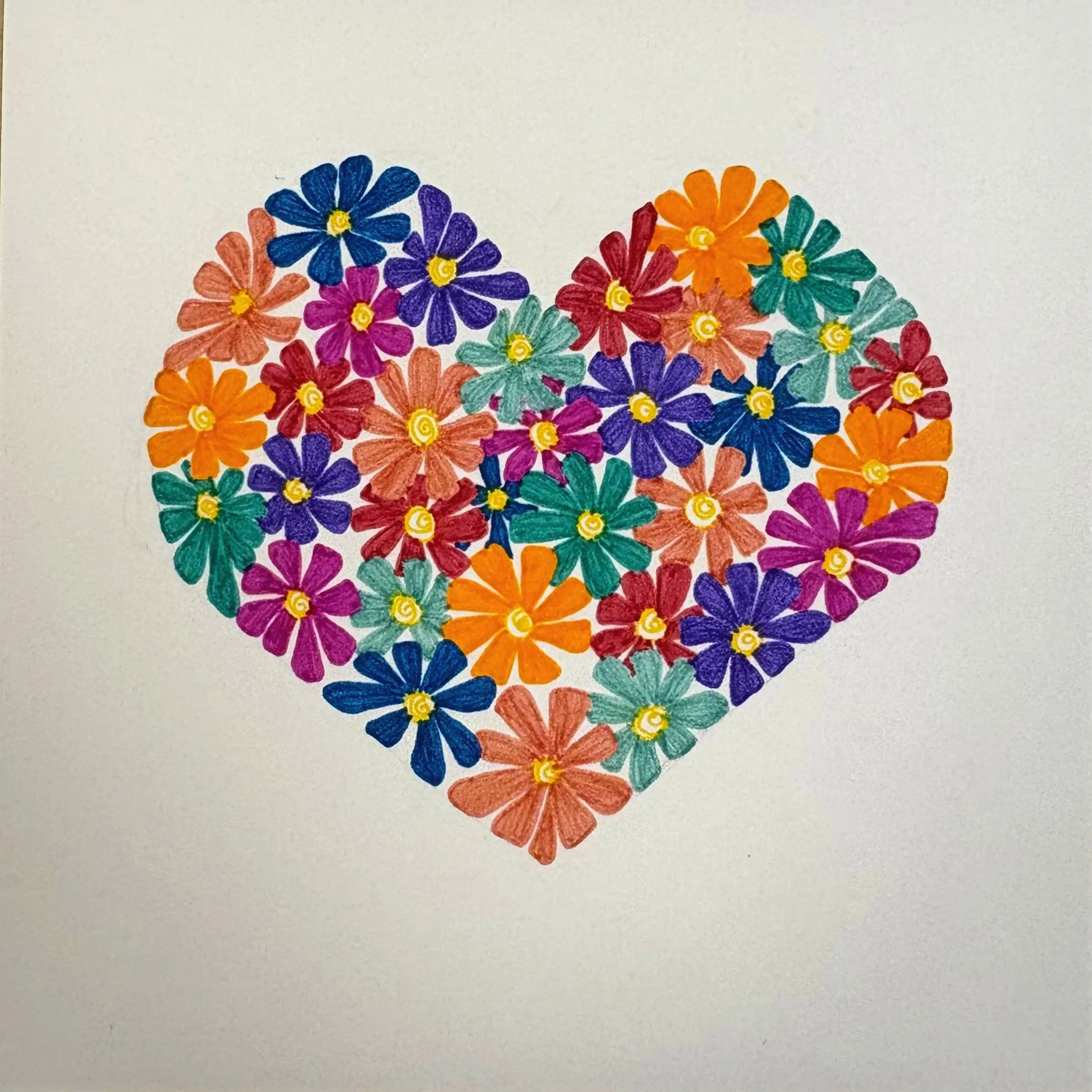 There is a heart shape made entirely of different color and shape flowers.