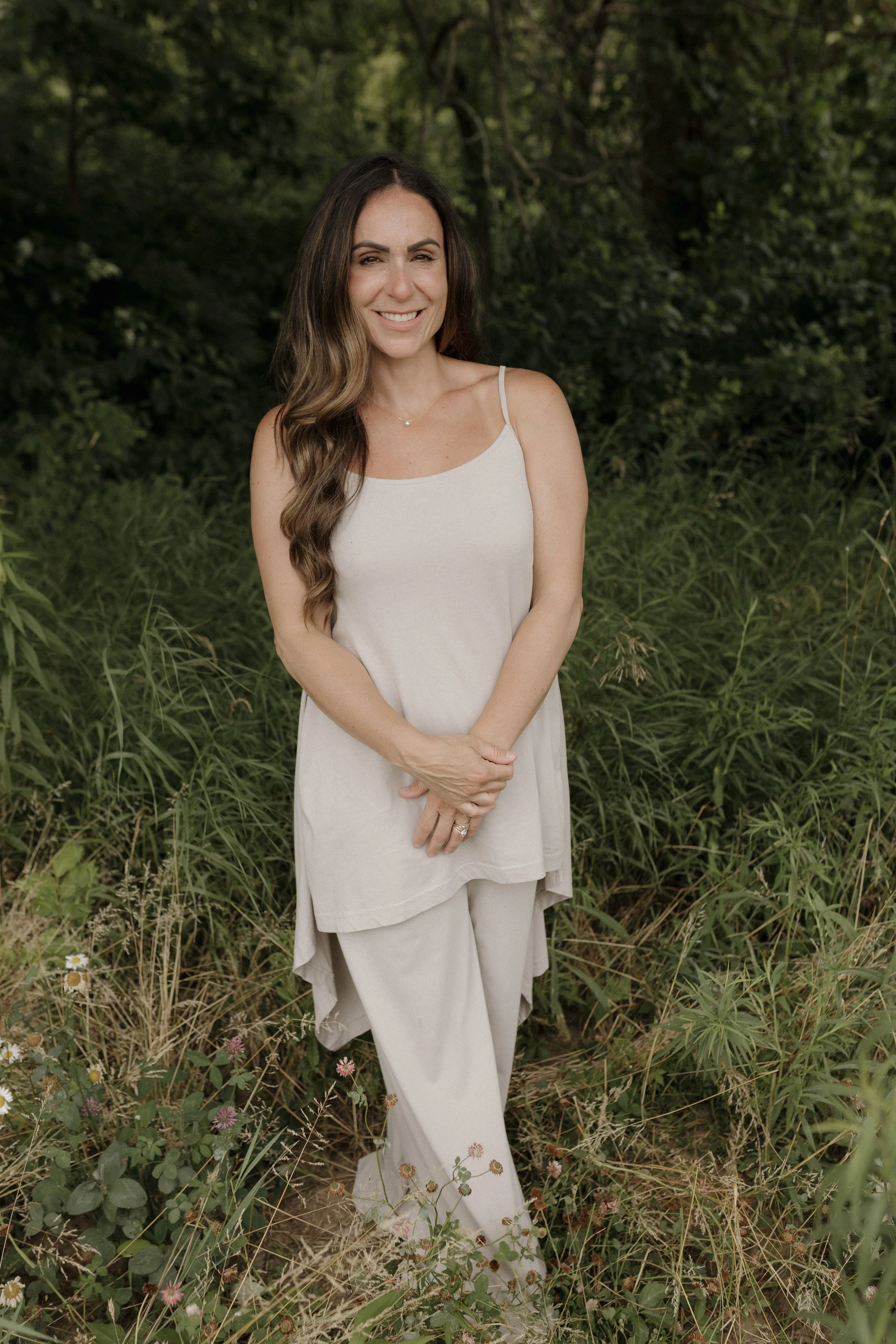 Alyssa M. Corbett standing outdoors in a wooded setting.