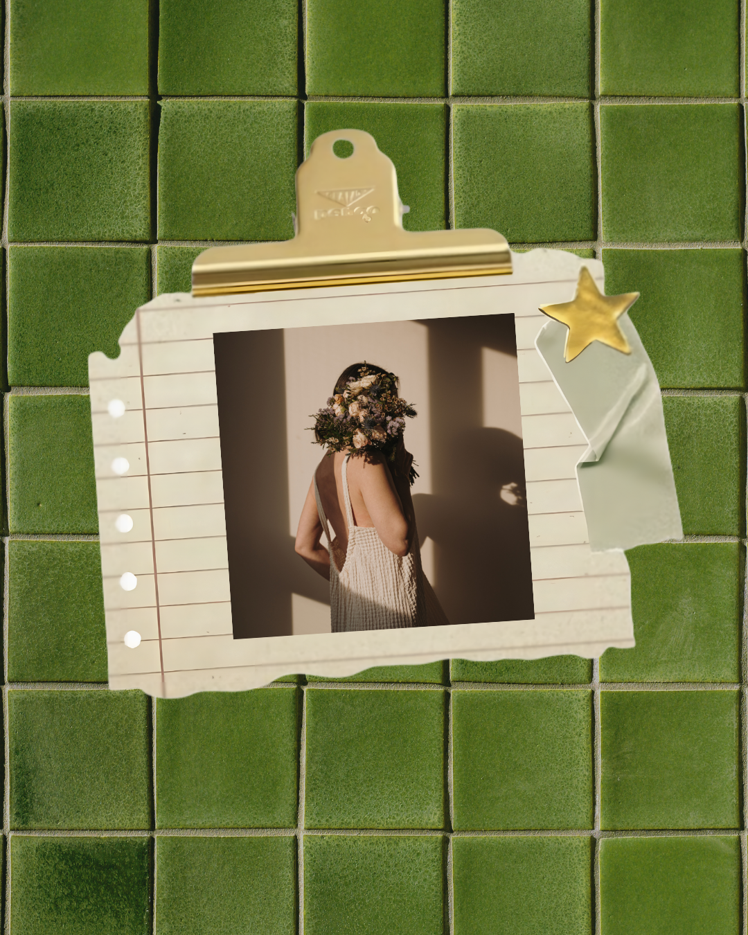 A photograph of a woman with a flower crown on her head, wearing a strap dress, standing with her back to the camera, and casting a shadow on the wall. The photo is taped to a script paper with a star-shaped clip, against a green tiled background.