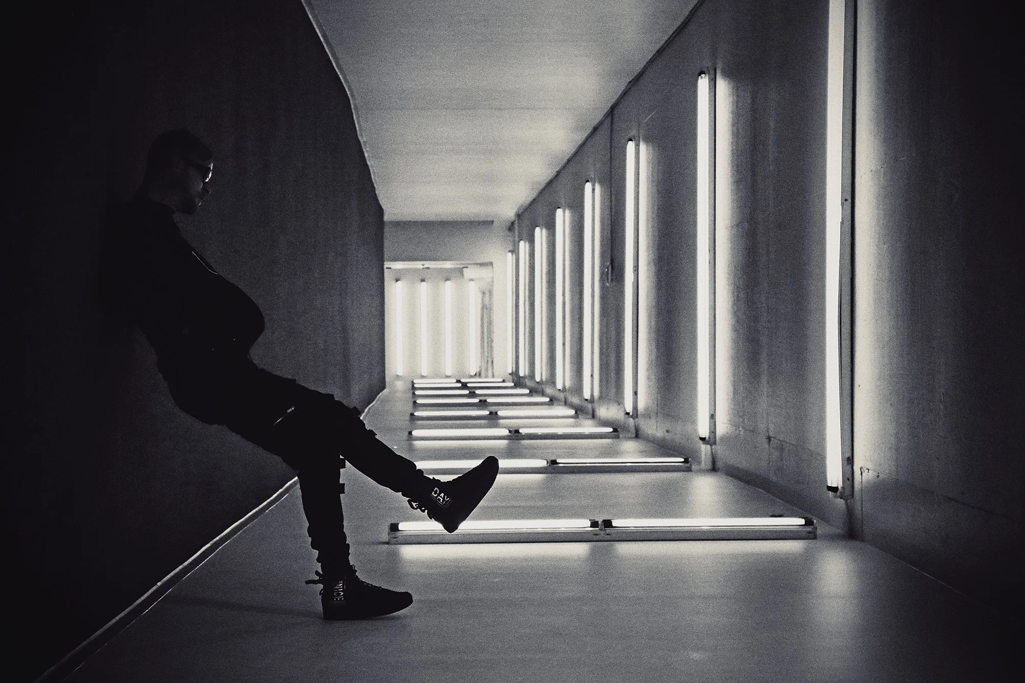Kyle Van Osdol is standing in a dimly lit corridor with modern light fixtures on the wall in the Oklahoma City Underground tunnels.