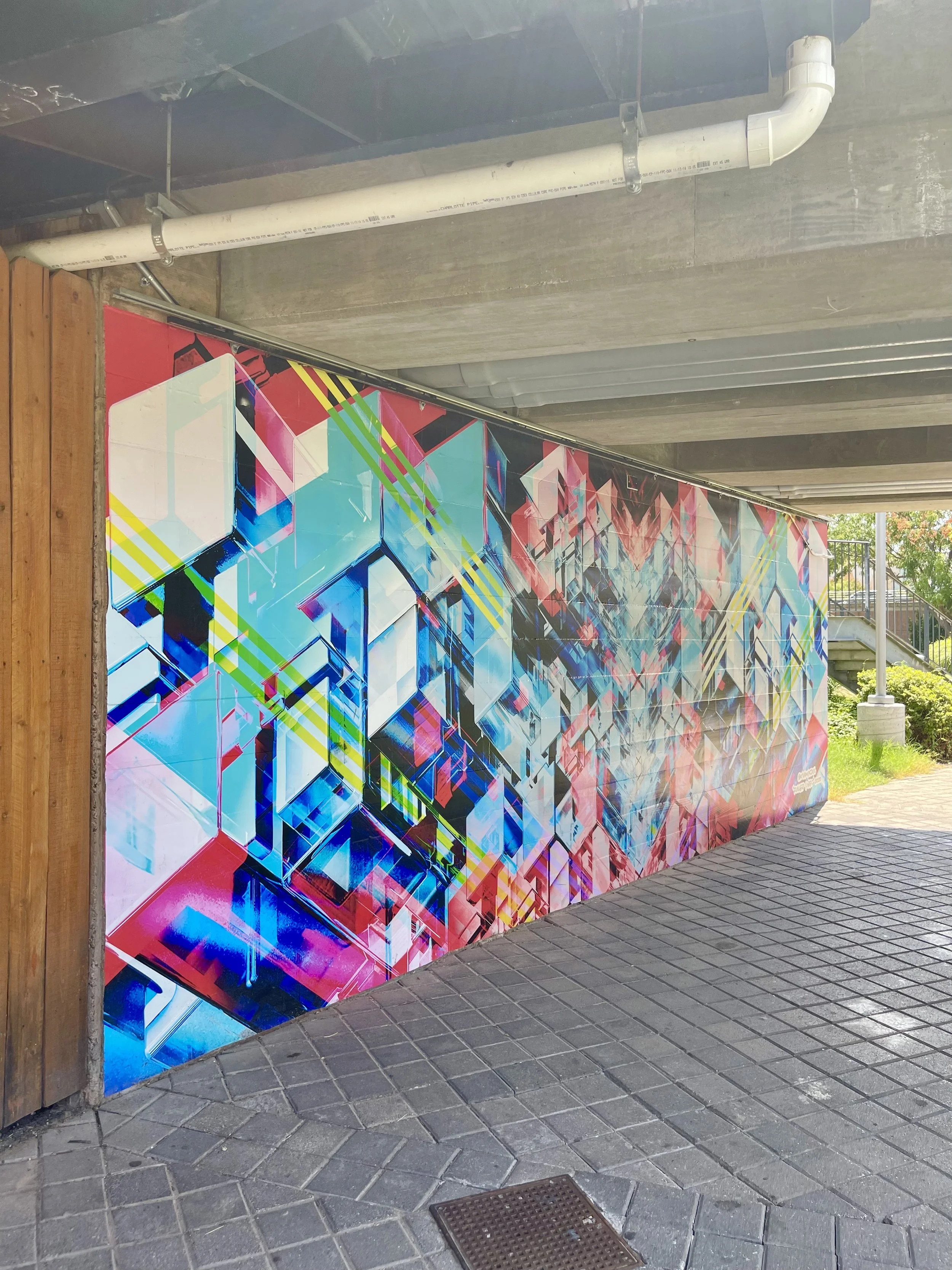 Colorful geometric artwork created by Kyle Van Osdol as a part of the Poles Apart installation located on a wall beneath an overpass in Bricktown in Oklahoma City.