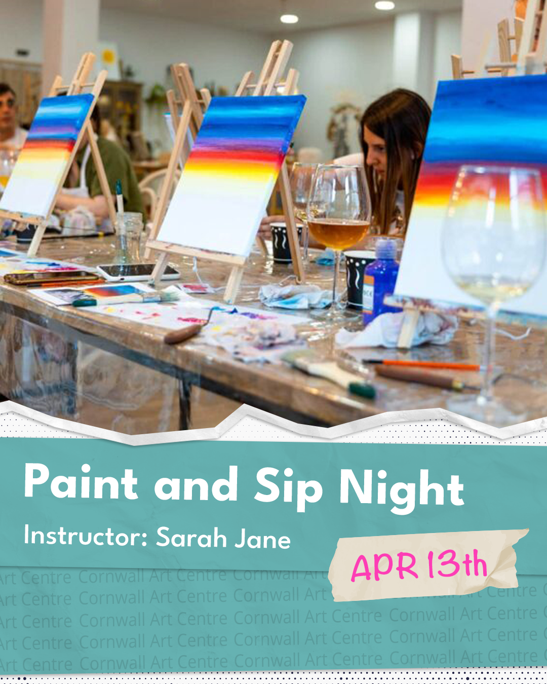 A group of people participating in a paint and sip event at an art studio, with easels, paints, and drinks on the table, while a woman is focused on her painting.