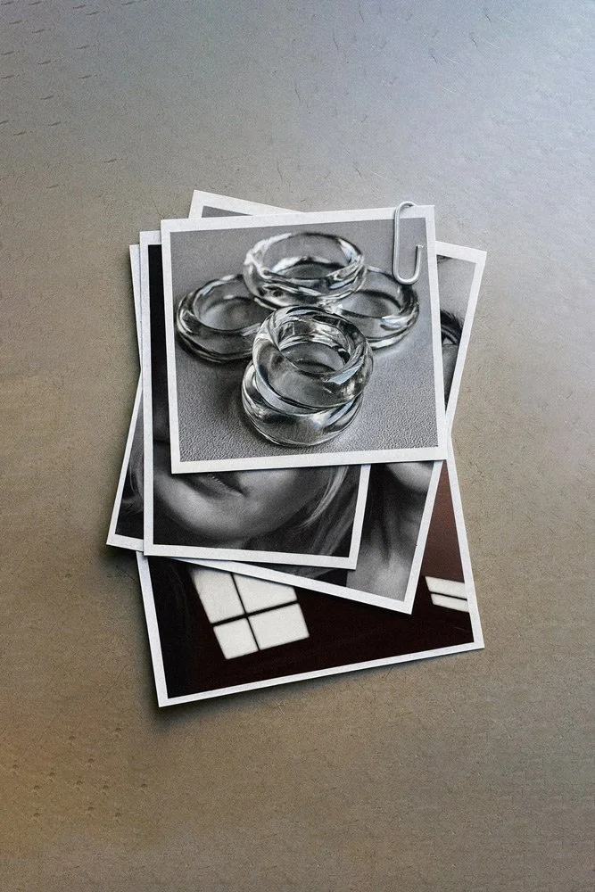 Black and white photographs, with the top one featuring three clear glass rings and a paperclip, all placed on a gray surface.