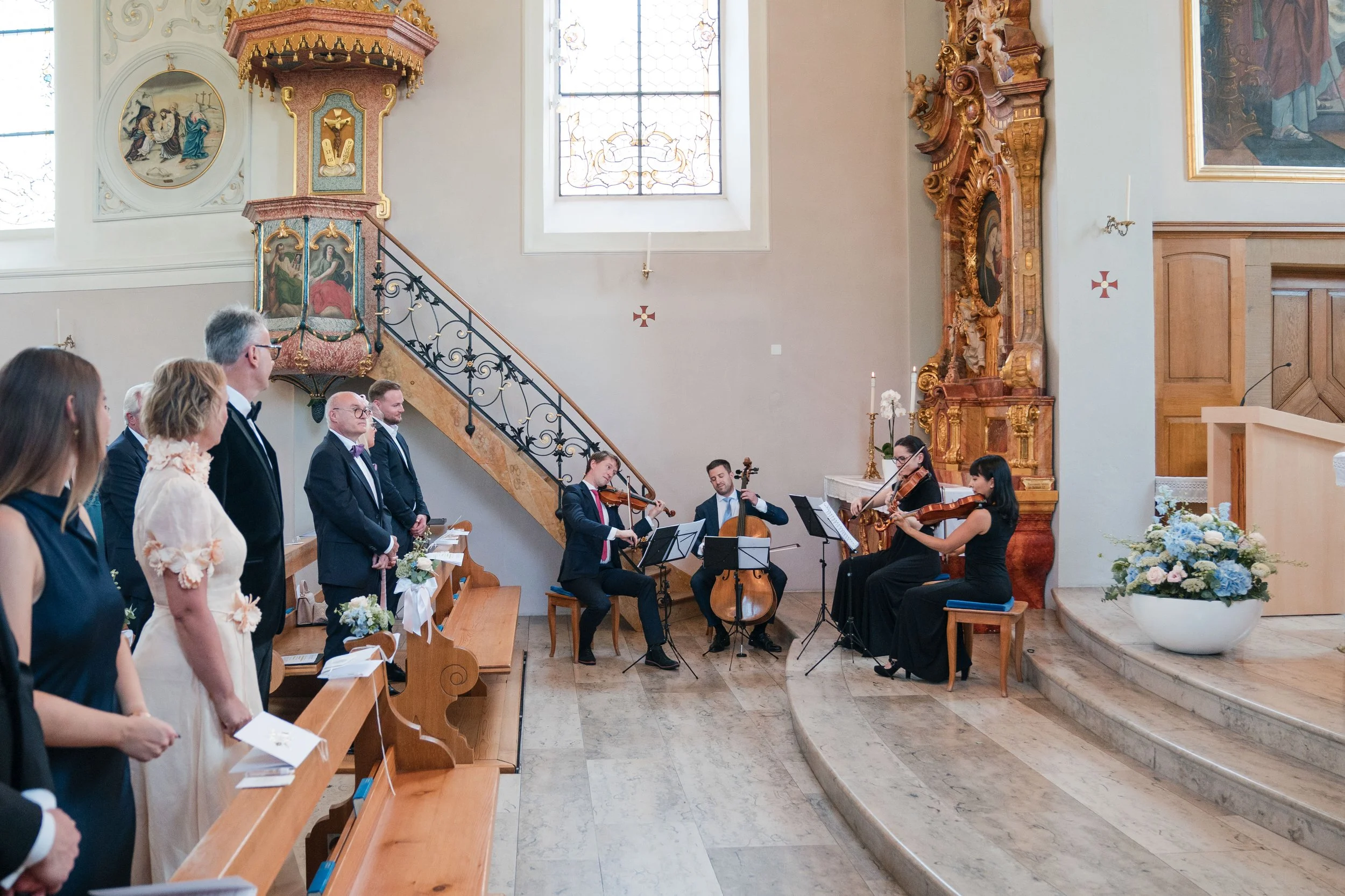 Eine Hochzeitszeremonie in einer Kirche mit einer Musikergruppe, die live spielt, während die Gäste zusehen.