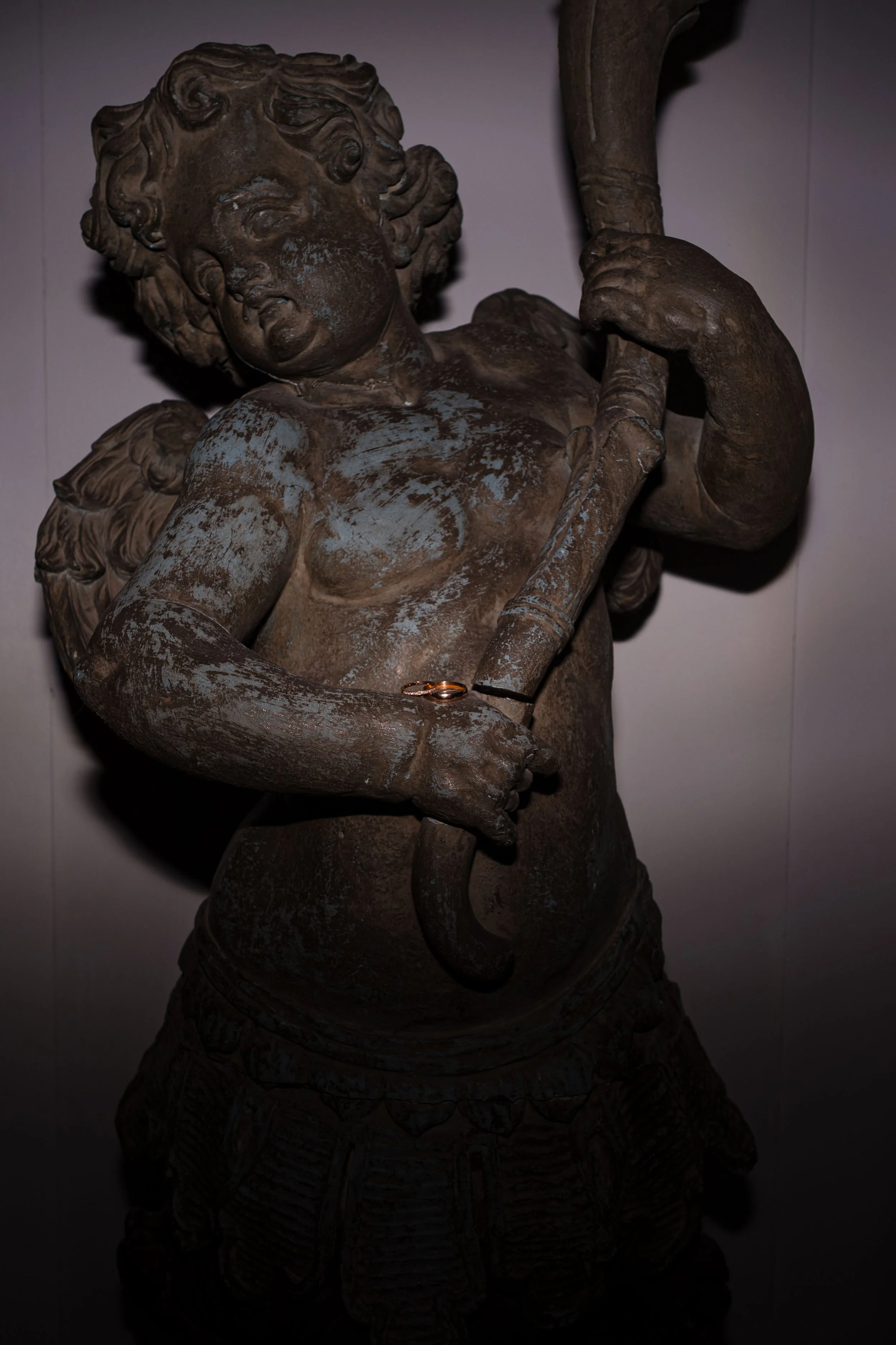 Bronzefigur eines Kindes mit Flöte, zeigt künstlerische Skulptur auf dunklem Hintergrund.