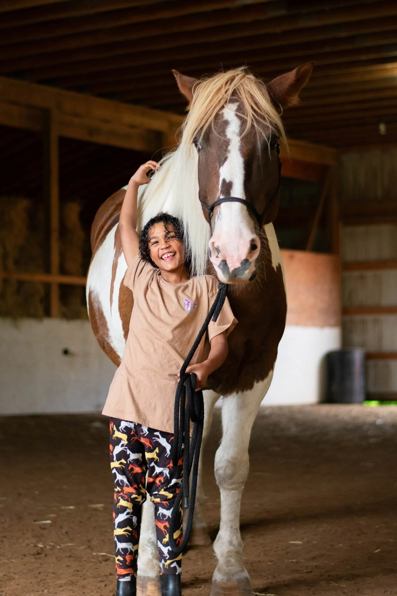 Child smiling with a horse during a family photography session in Ann Arbor, MI