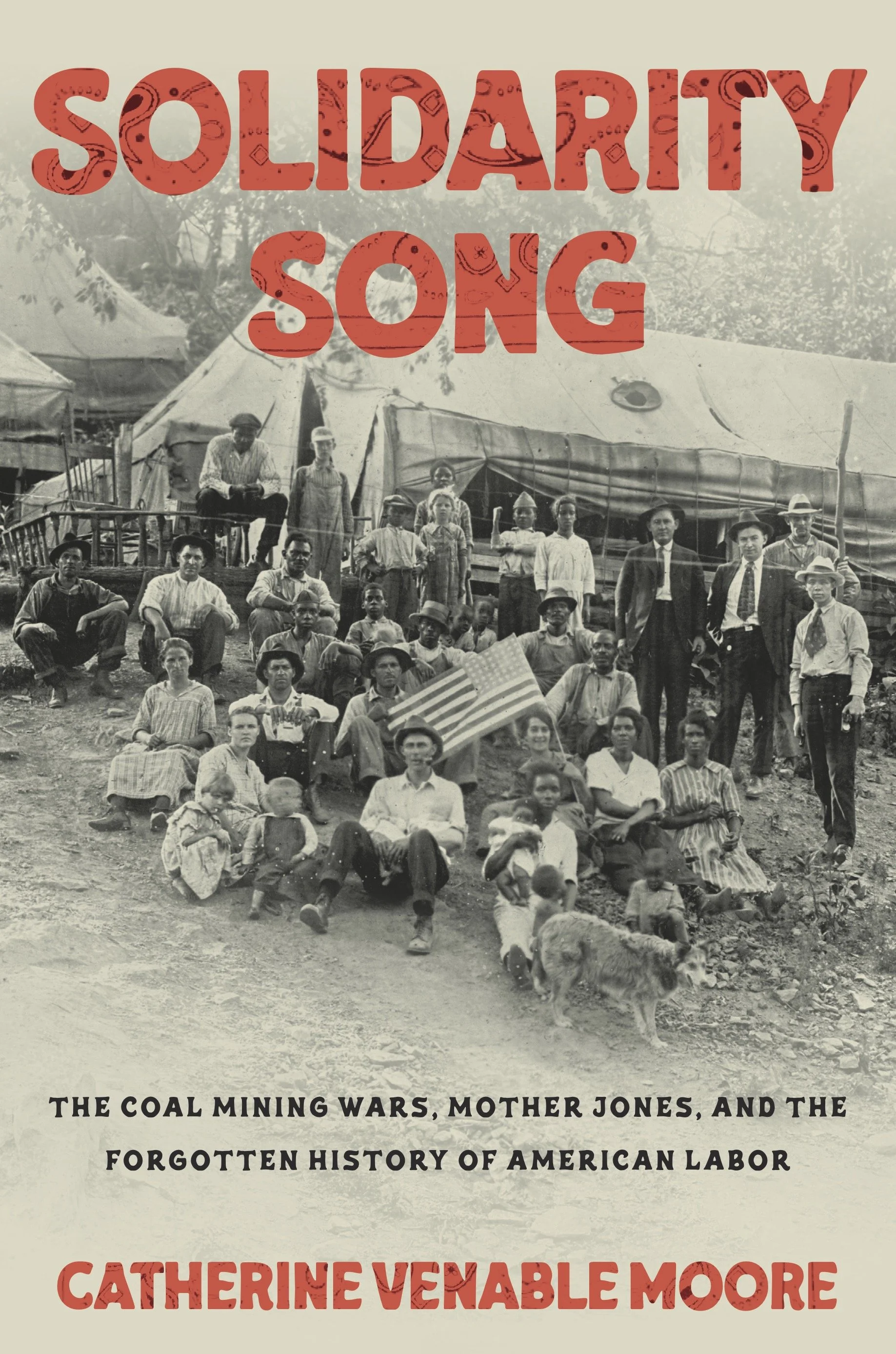A historical black and white photograph of a large group of diverse people, including children, gathered in front of tents and a wagon, with trees in the background. Overlaid text reads 'SOLIDARITY SONG' in large red letters, and below it is a subtitle about the coal mining wars, Mother Jones, and forgotten history of American labor.