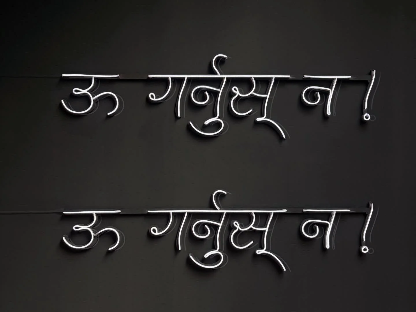 Neon sign in Devanagari script with a black background.