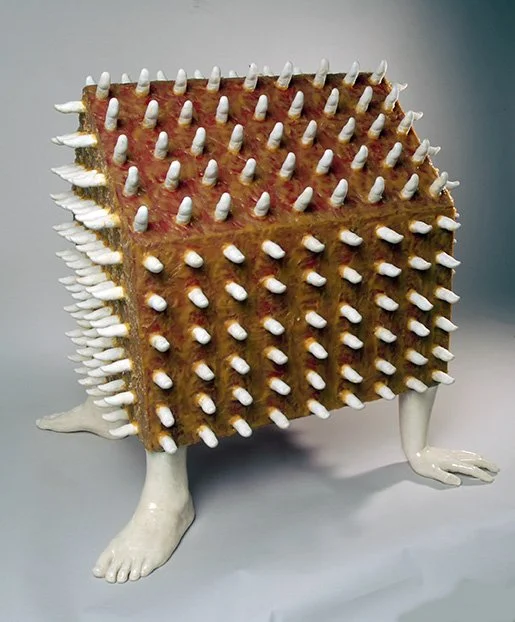 A sculpture of a creature with a rectangular body covered in white spikes, a fur-like texture, and animal-like limbs and feet.