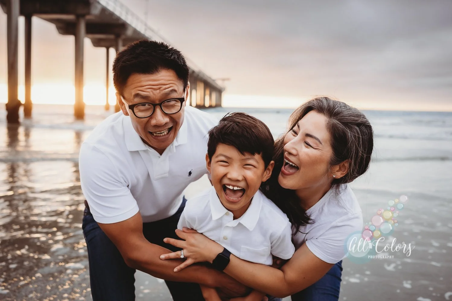 Mom, dad and son being playful at Scripps Pier in La Jolla