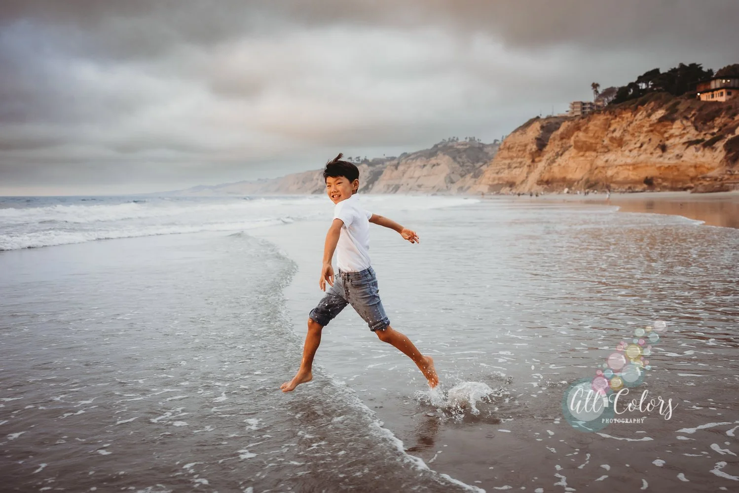 boy running on the beach and splashing water