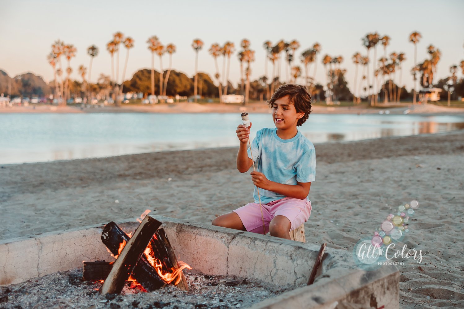 photo of a child making s'mores on a beach