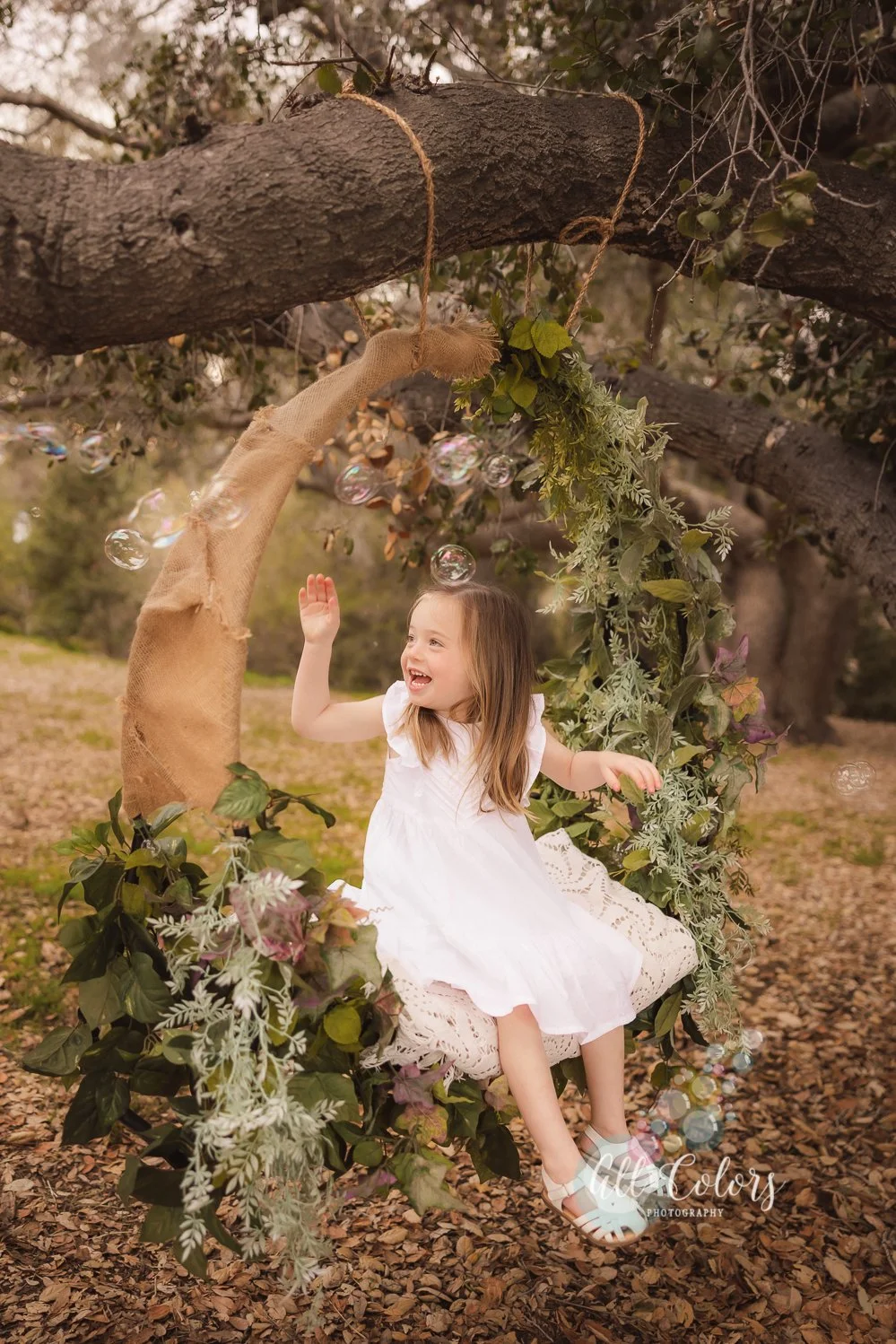 Little girl on a Flower Swing/Flower Hoop playing with bubbles.