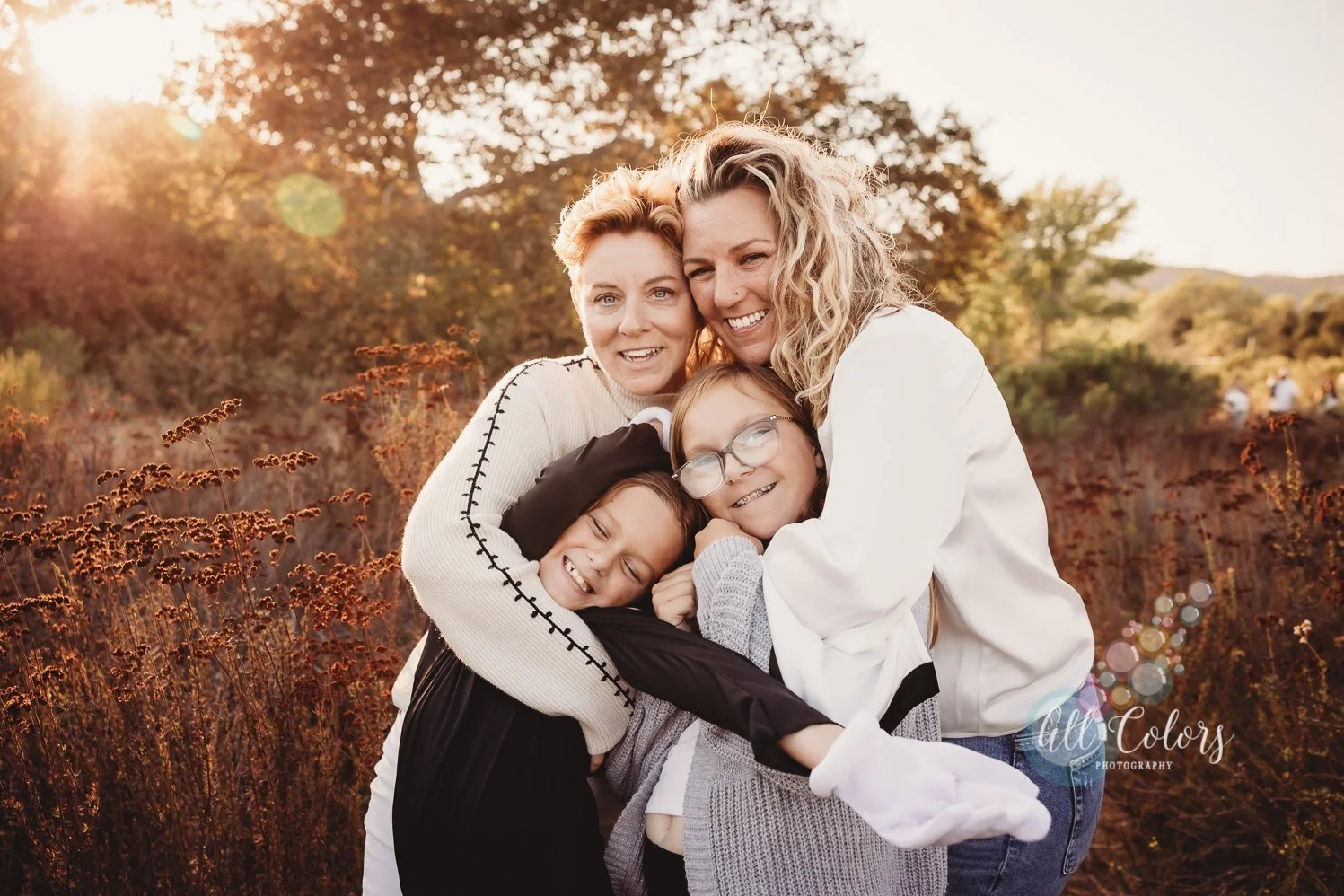 Two moms hugging their 2 daughters on a trail in San Diego, CA.