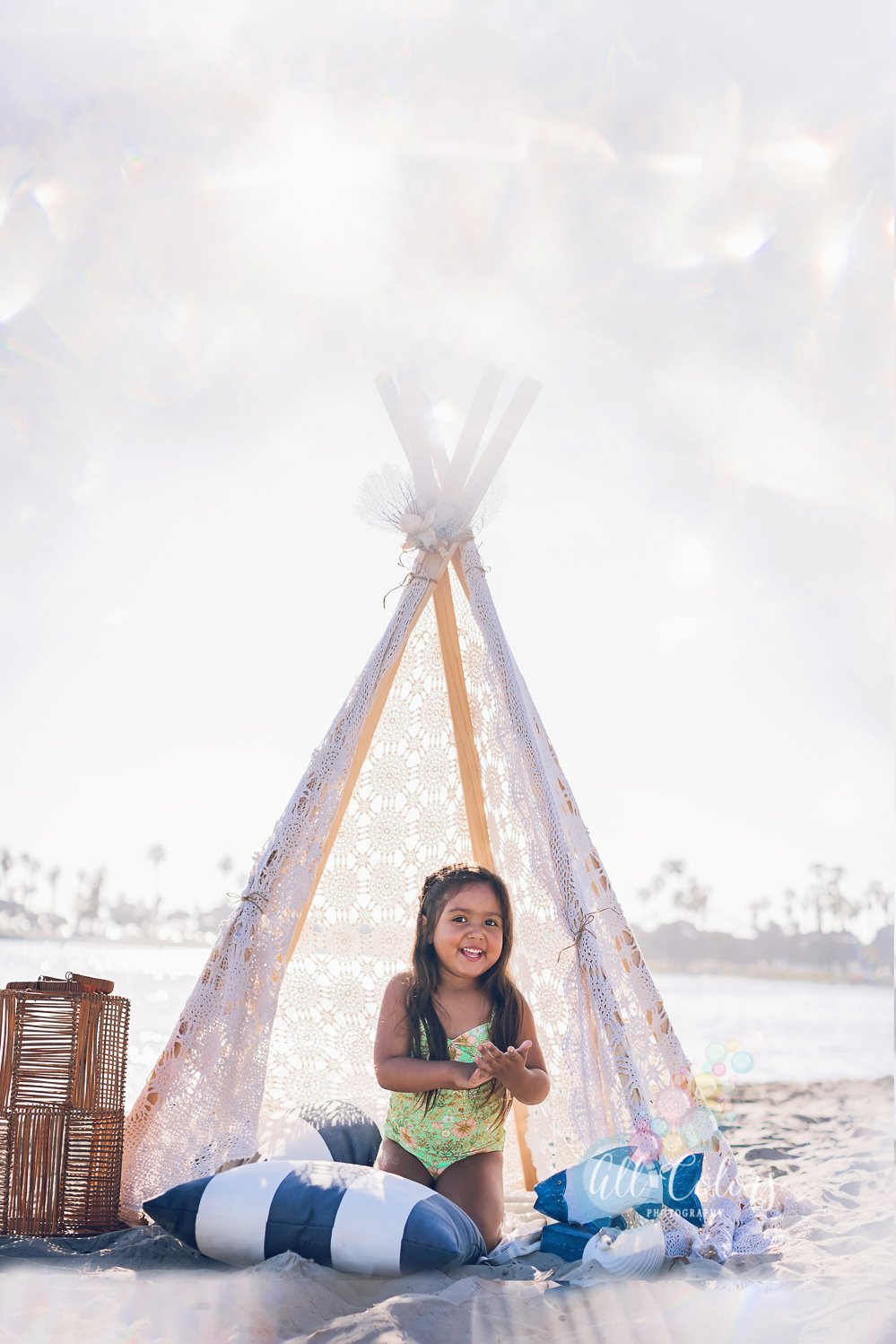 girl sitting inside a boho teepee at the beach in San Diego, ca