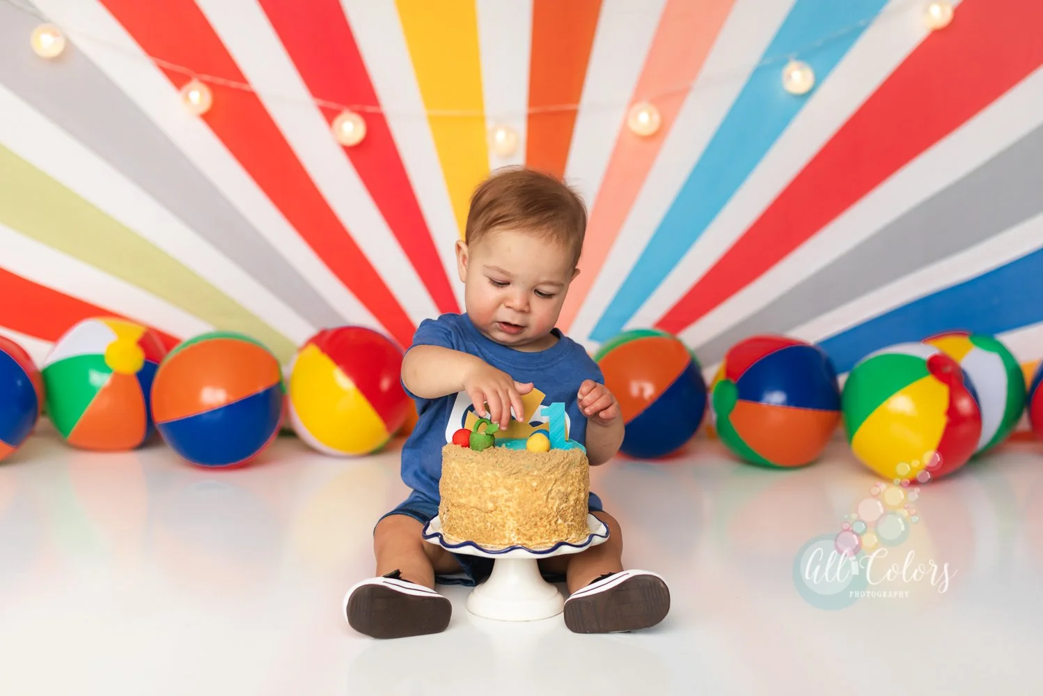 Little boy touching a cake during a cake smash session in studio.