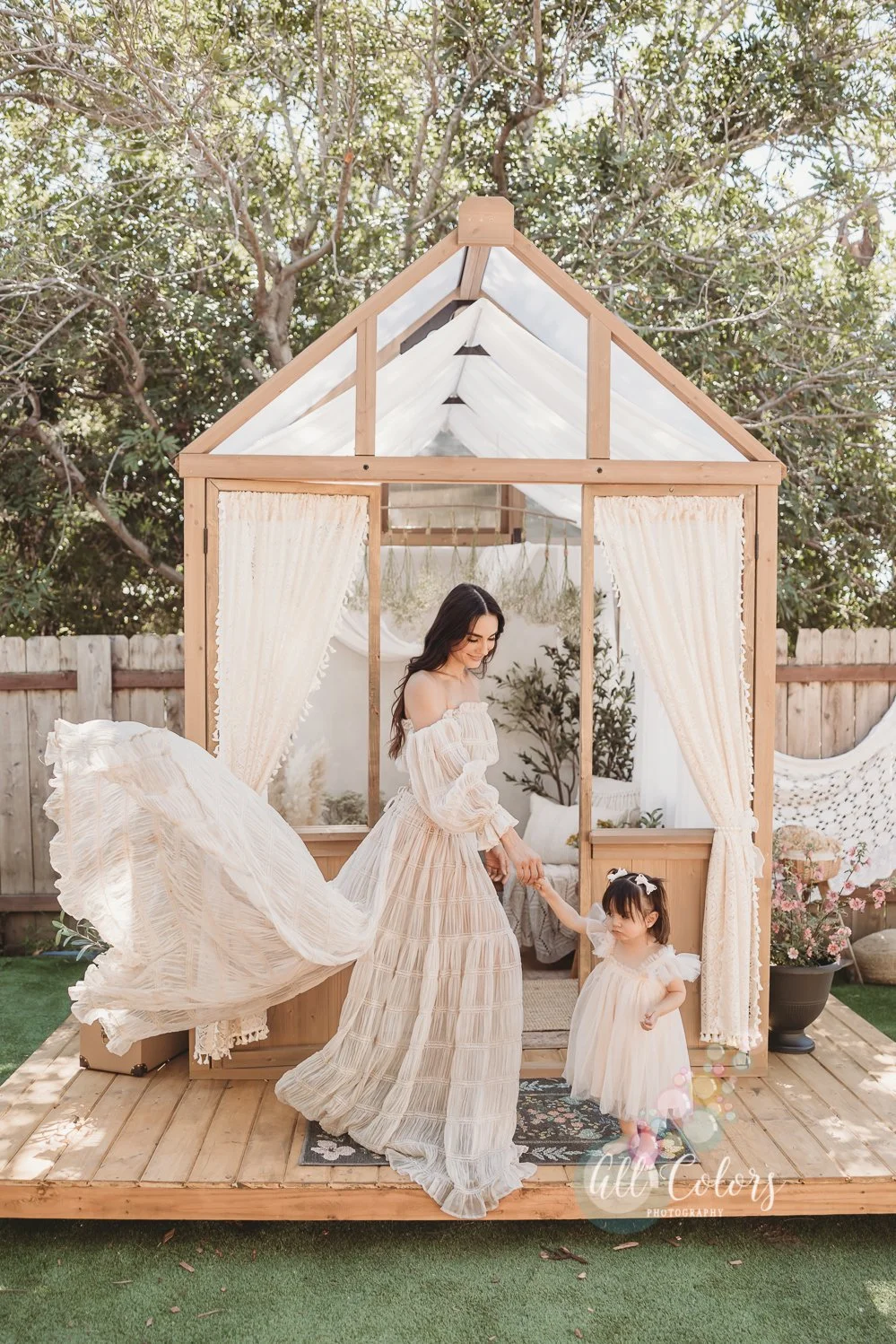 Mom and daughter in front of a green house