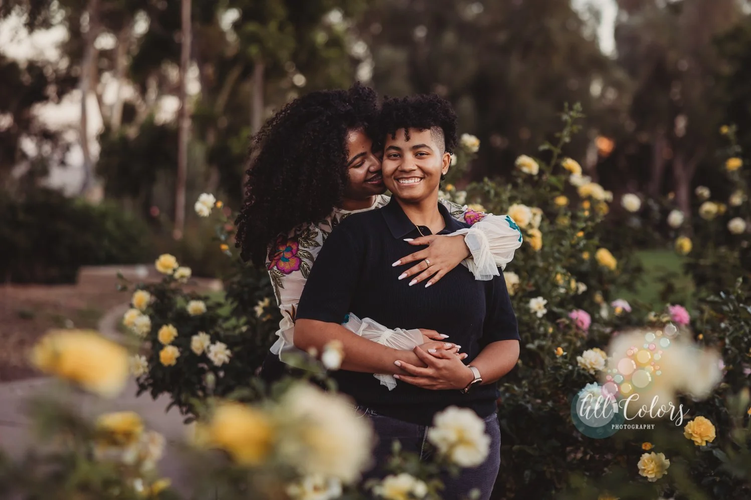 Couple hugging in the middle of yellow roses