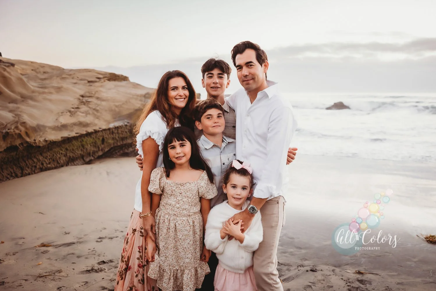 family at the beach wearing pastel colors