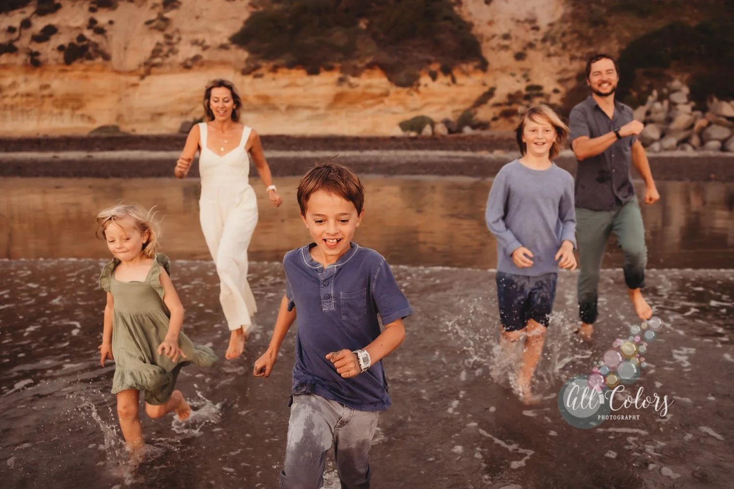 Mom, dad and three kids running to the ocean in a very candid photoshoot in Encinitas, CA.