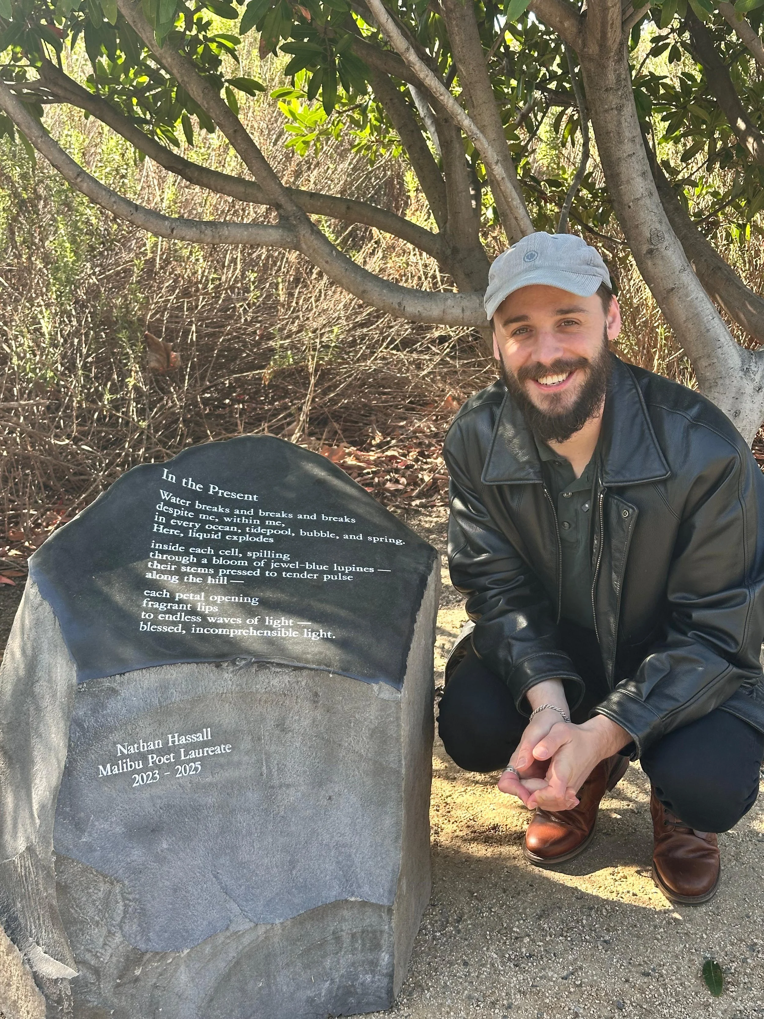 Malibu Poet Laureate Emeritus Nathan Hassall stands next to his 2-tonne poetry stone in Legacy Park