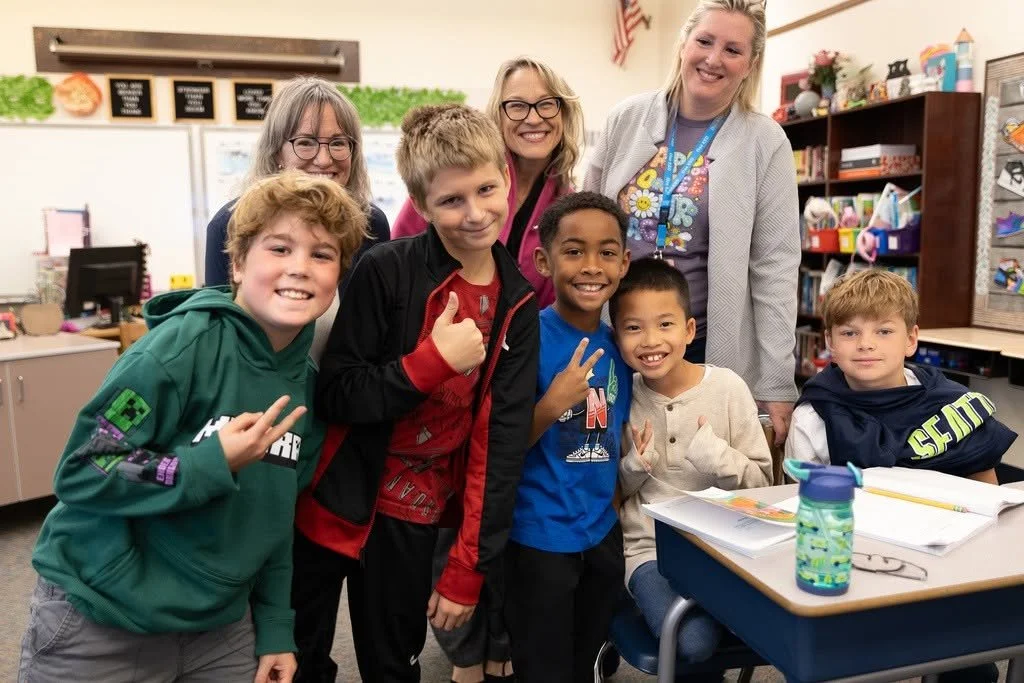 A group of six children and three teachers in a classroom, smiling and posing for a photo.