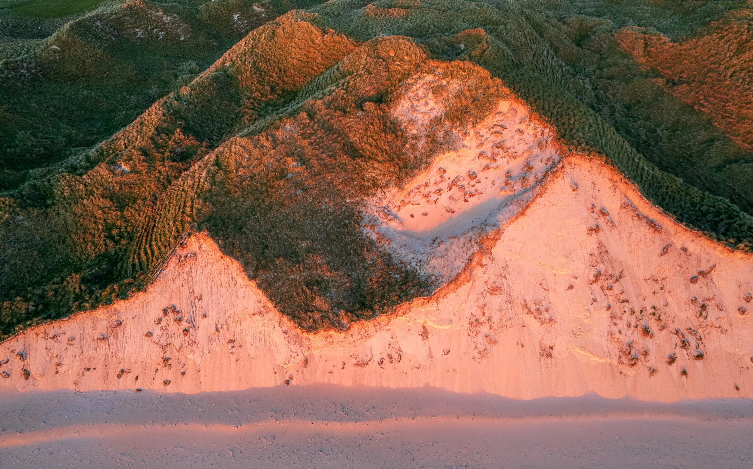 Drone landscape photograph of the sand dunes at Five Fingers Strand, County Donegal, shaped by low golden evening light.