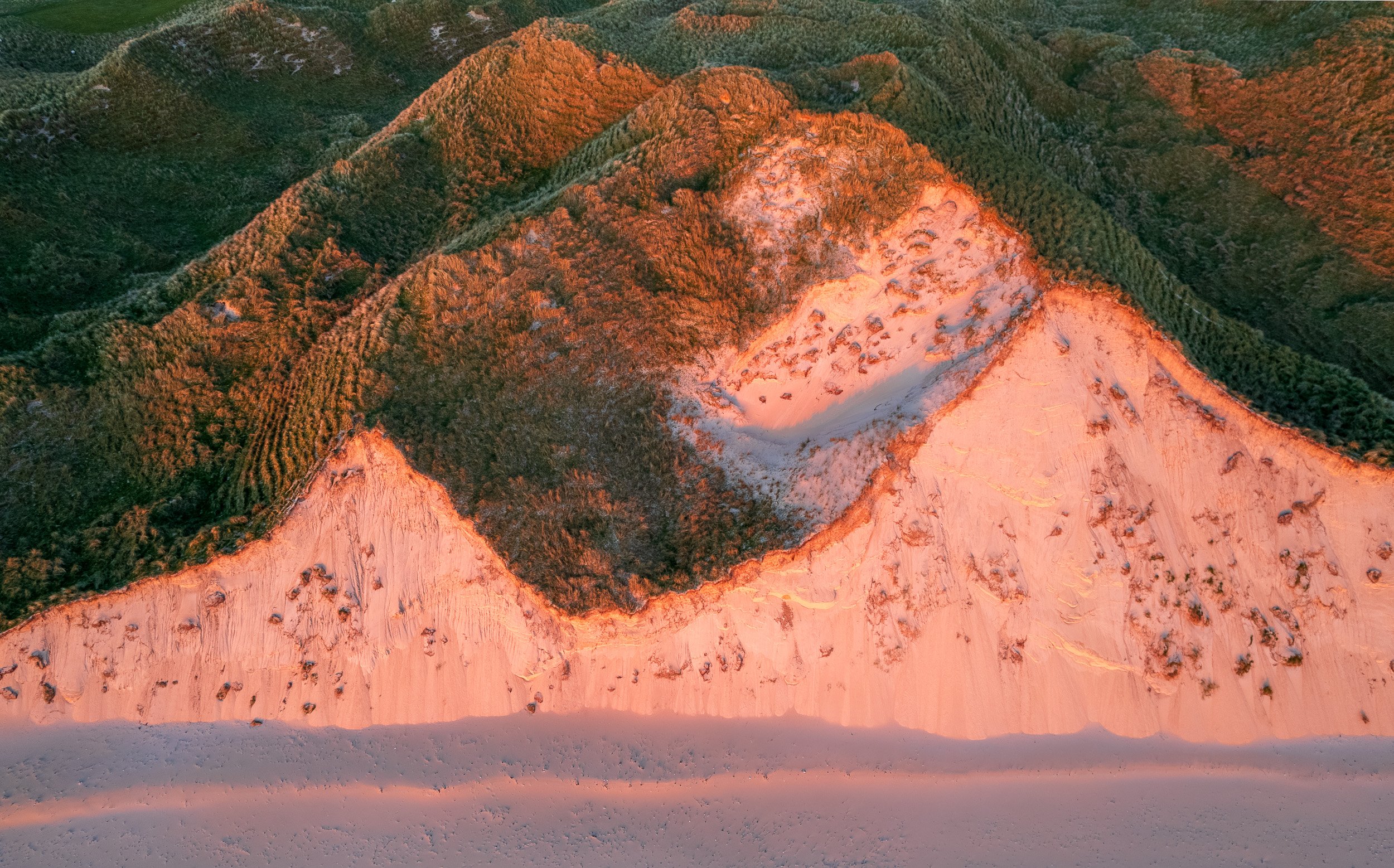 Aerial landscape photograph of the sand dunes at Five Fingers Strand, County Donegal, Ireland at sunset.