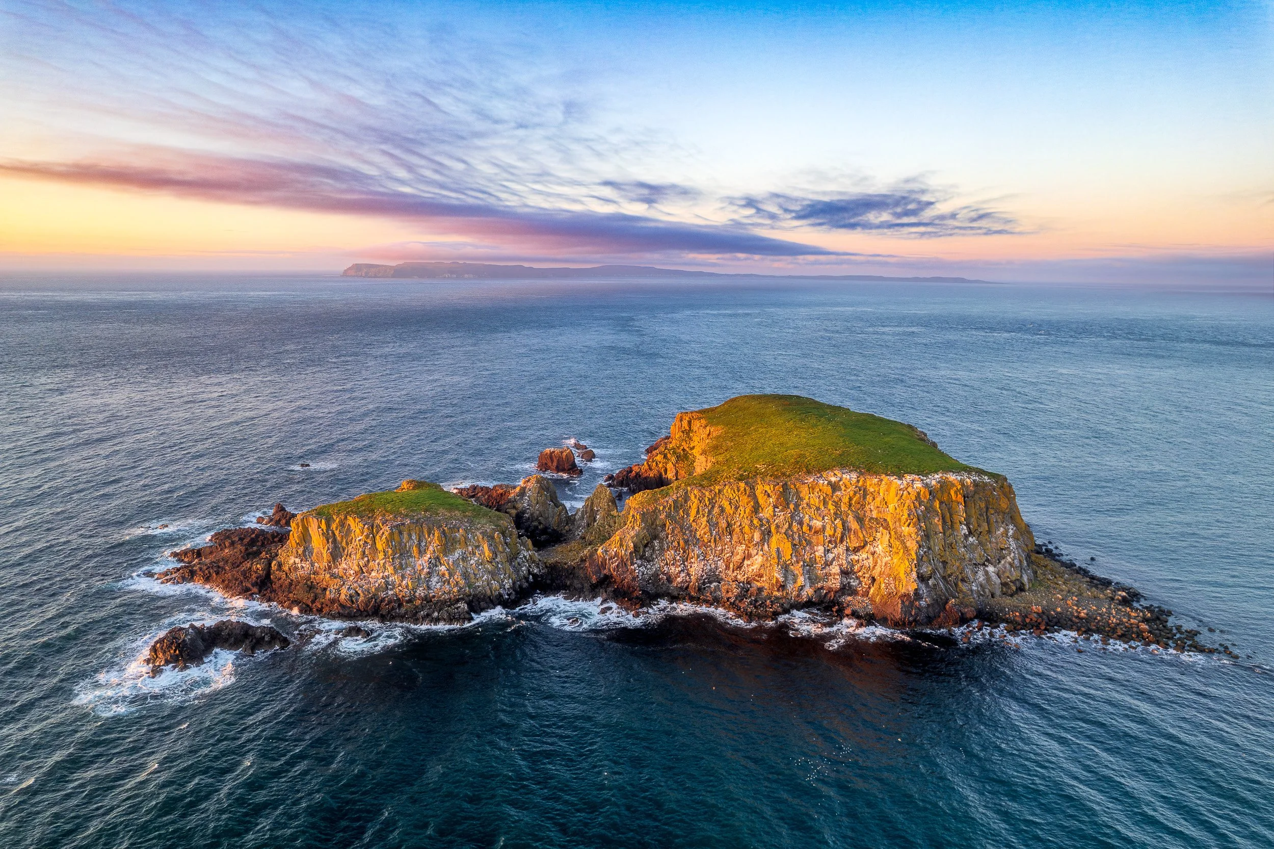 Aerial landscape photograph of Sheep Island off Ballintoy on Northern Ireland's Causeway Coast at sunset.