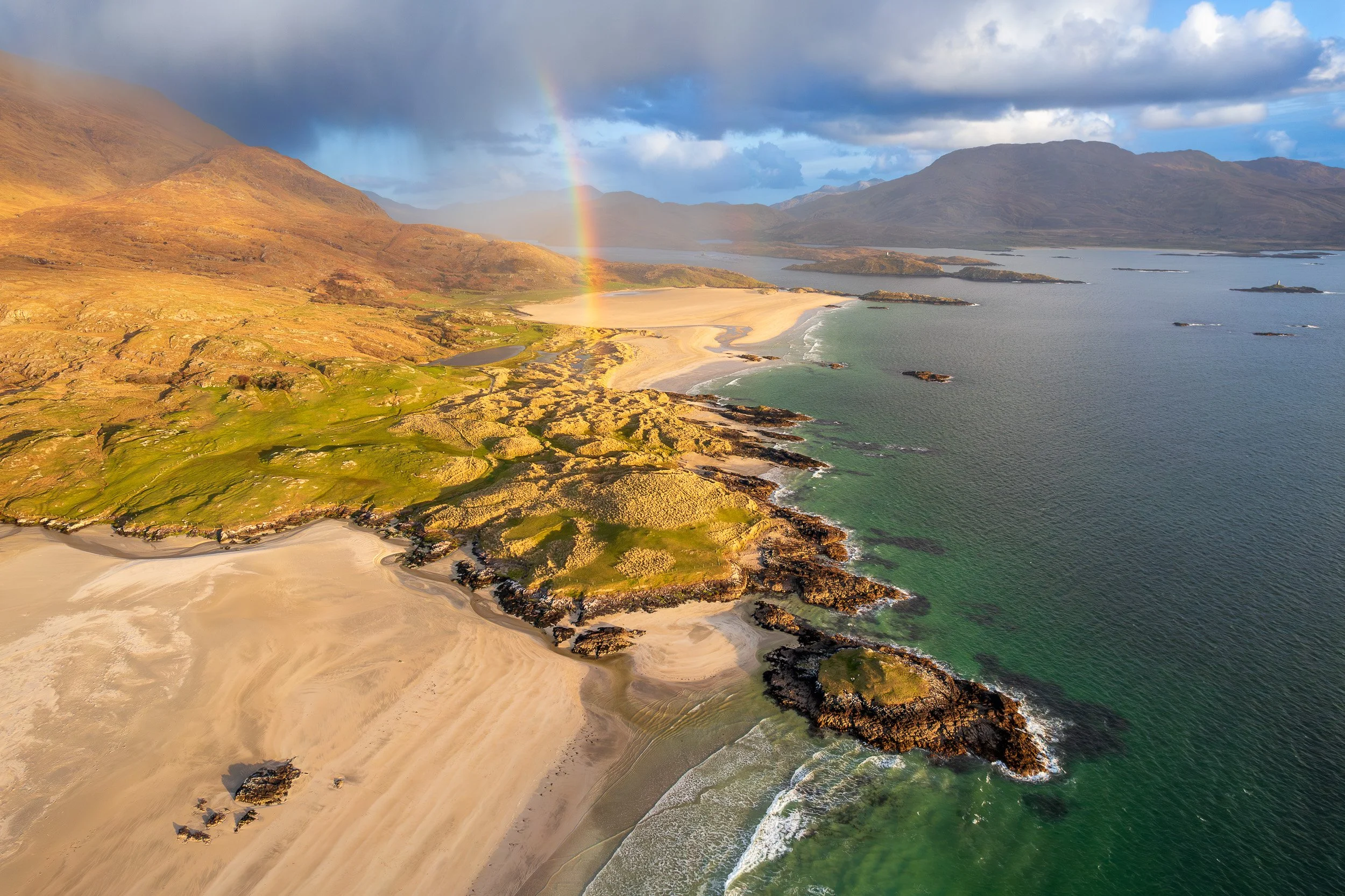 Aerial landscape photograph of a rainbow over Uggool Beach and the Lost Valley, County Mayo, Ireland.
