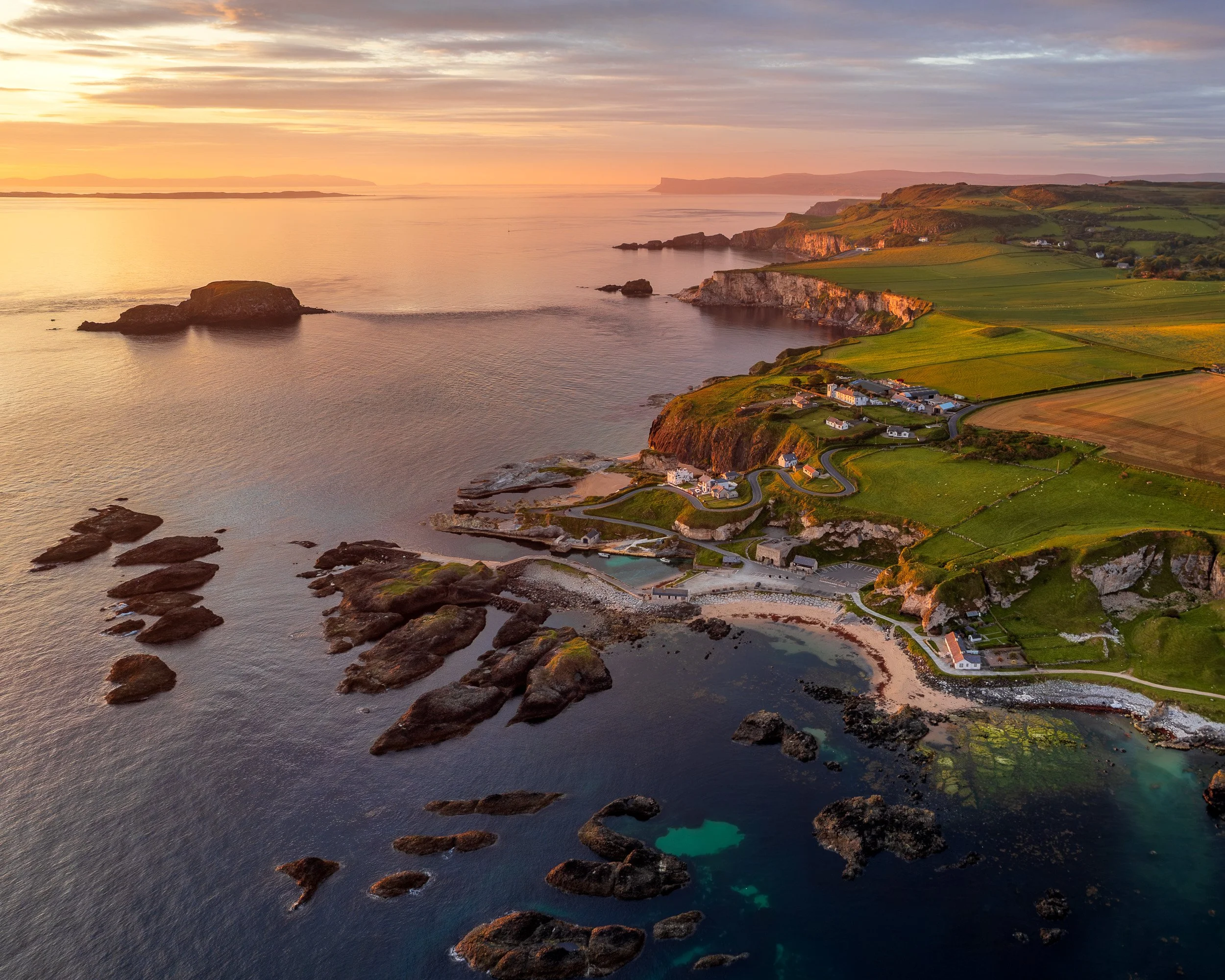 Aerial landscape photograph of Ballintoy, Northern Ireland at sunrise.