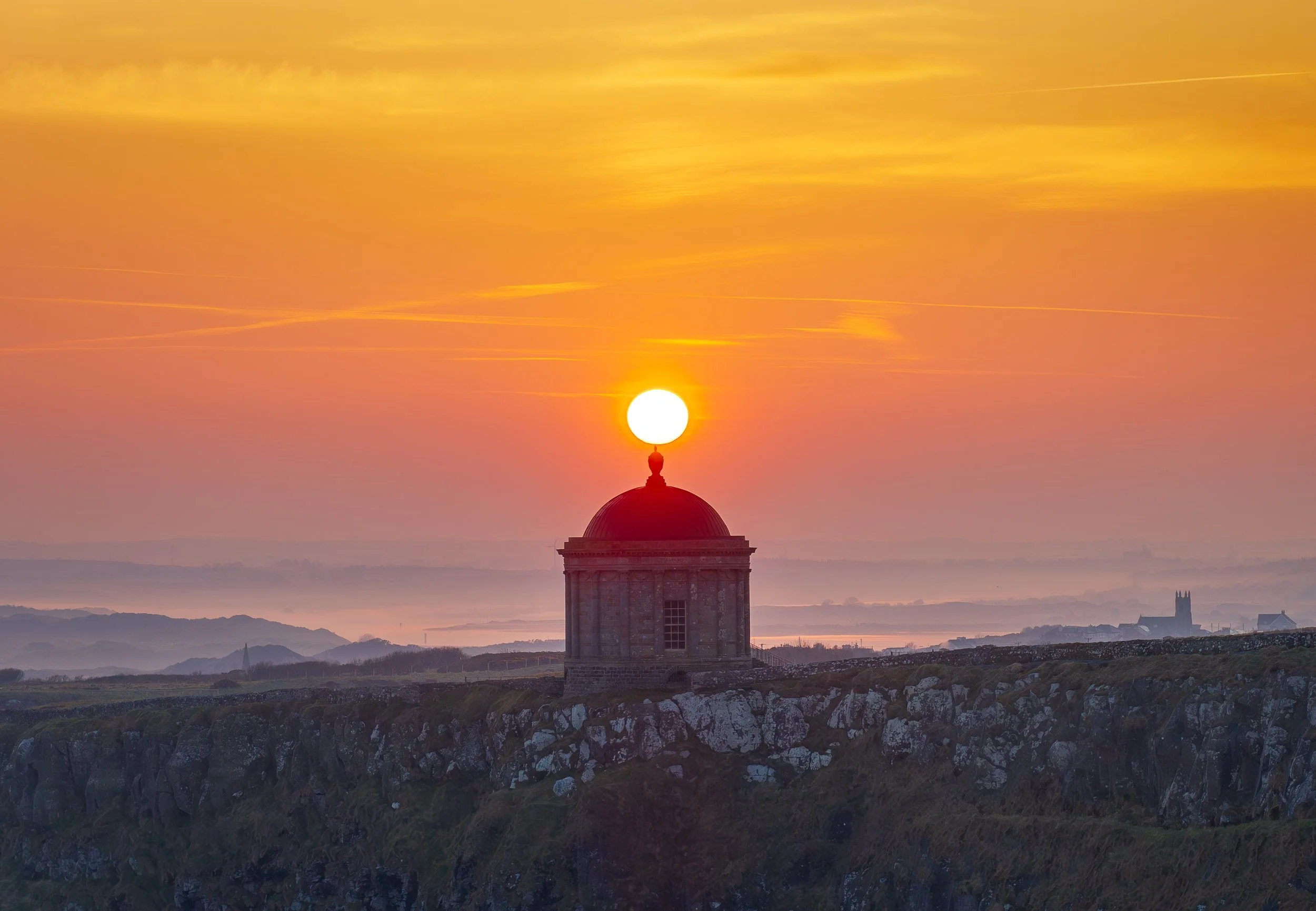 Aerial landscape photograph of Mussenden Temple, Castlerock, Northern Ireland at sunrise.