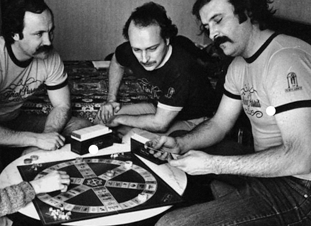 Three of the Trivial Pursuit creators [John Haney, Scott Abbott, Chris Haney] playing an early edition of the game in the early 1980s.